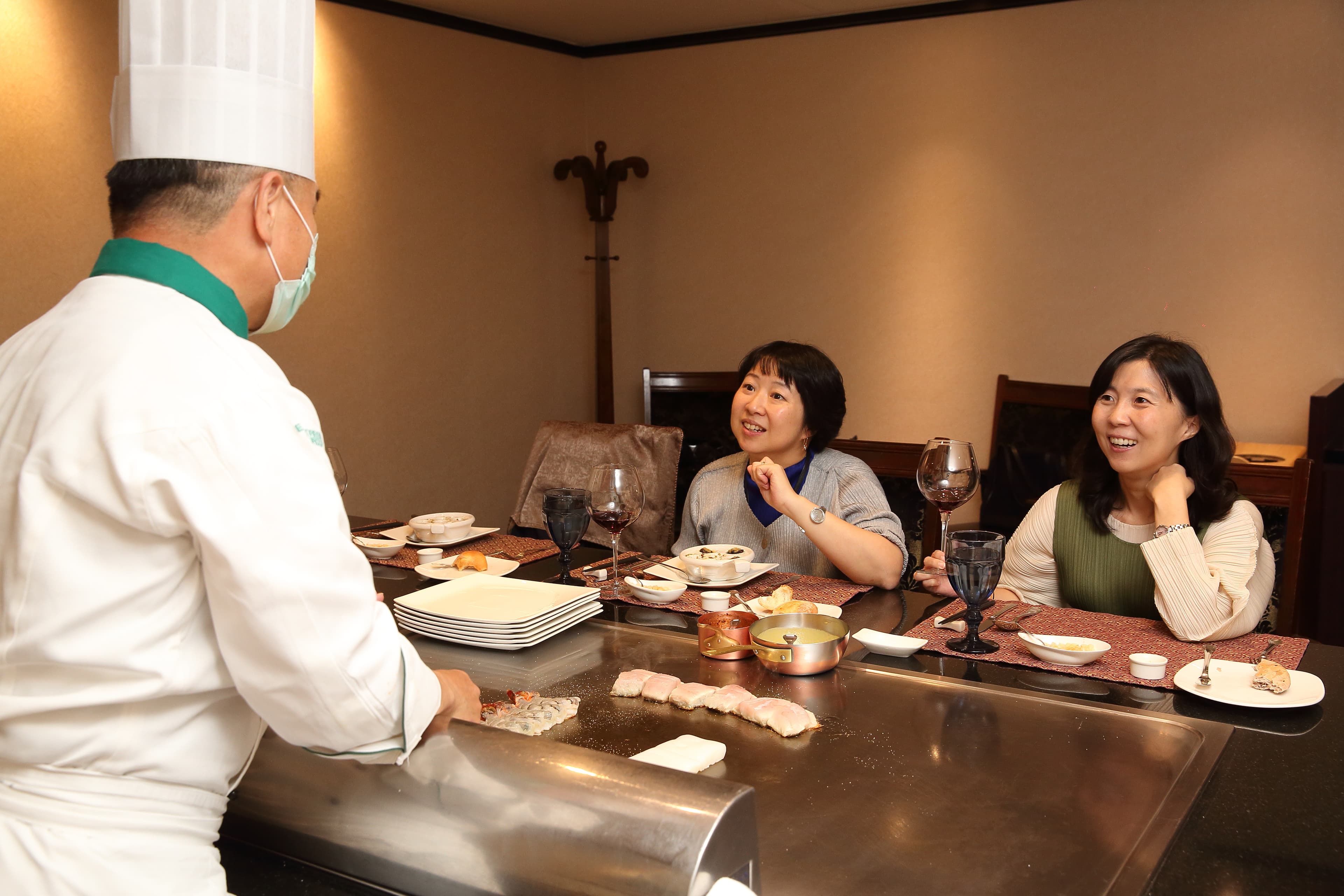 冠品鐵板燒主廚曹茗欽為林佳沛（右）、林玫芸（左）姊妹重現當年父親熱愛的鐵板美食。
