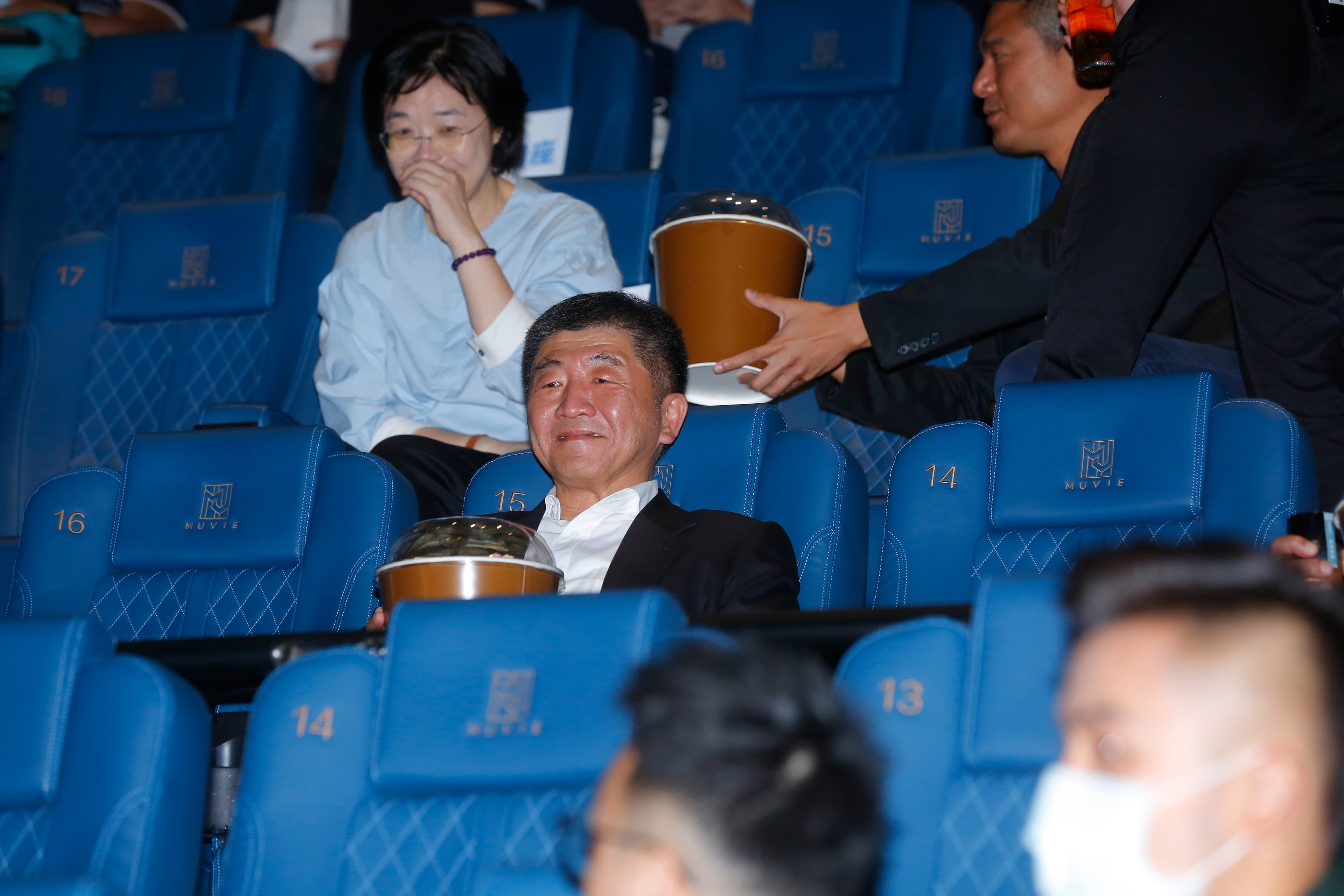 衛福部陳時中部長抱著大桶爆米花示範在看電影時保持社交距離的安心吃法。