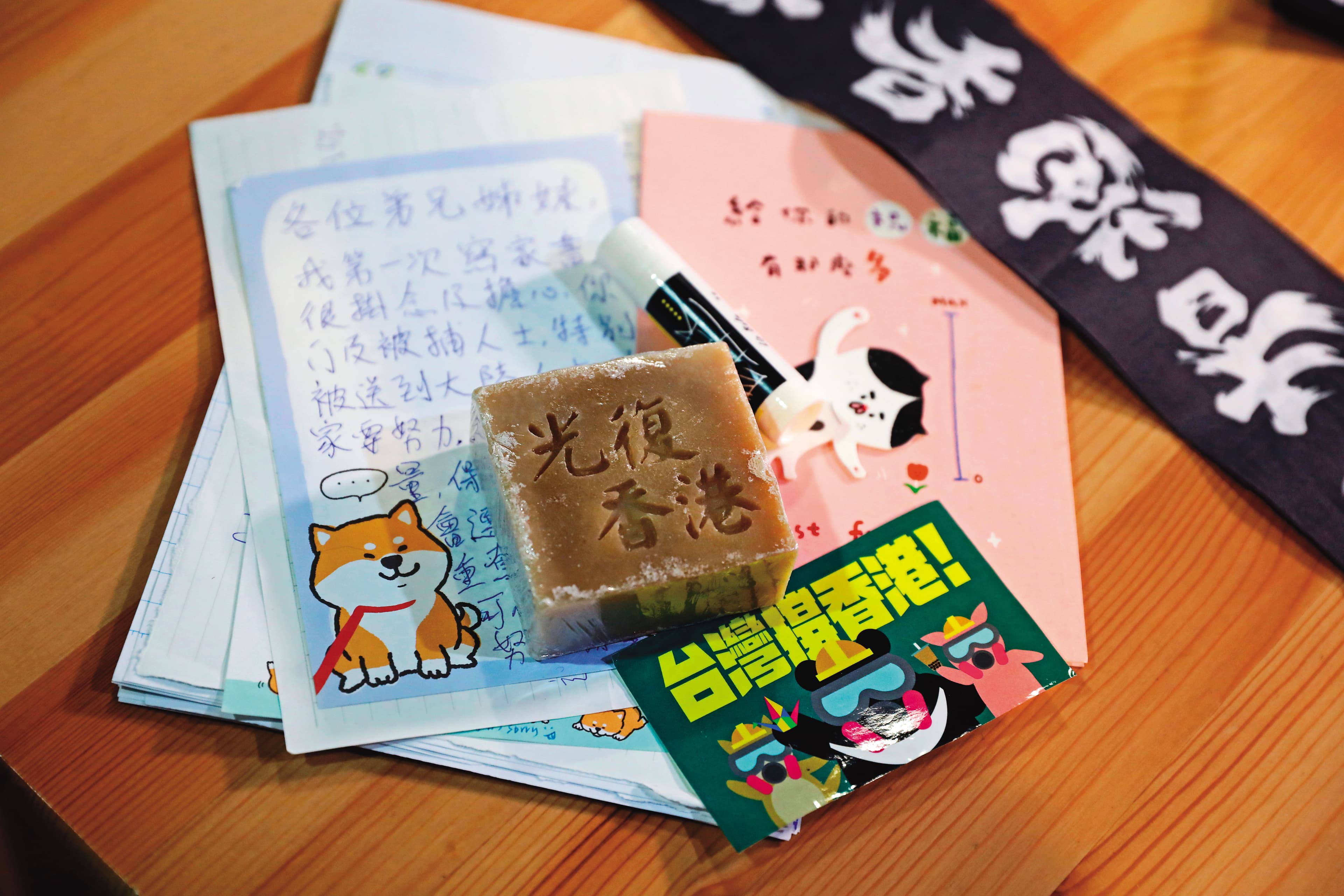Absent有顆少女心，細心保存許多港人寄到台灣的卡片、信件、貼紙。圖中刻有「光復香港」的肥皂，是流亡港人以手工自製。