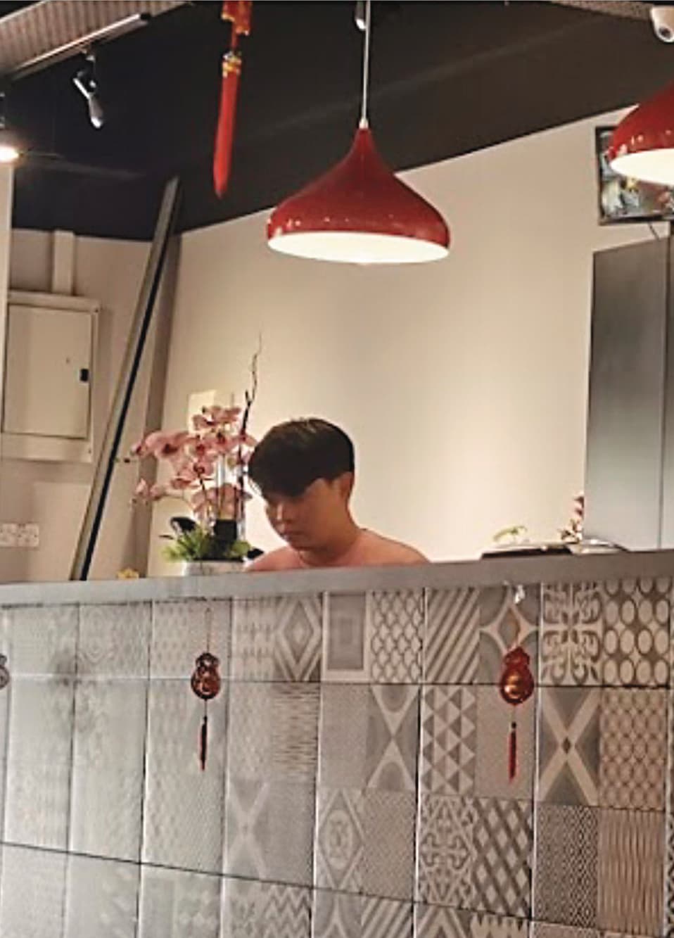 假富商鄭楚豪（圖）和盛女在麻六甲店內忙進忙出。（讀者提供）