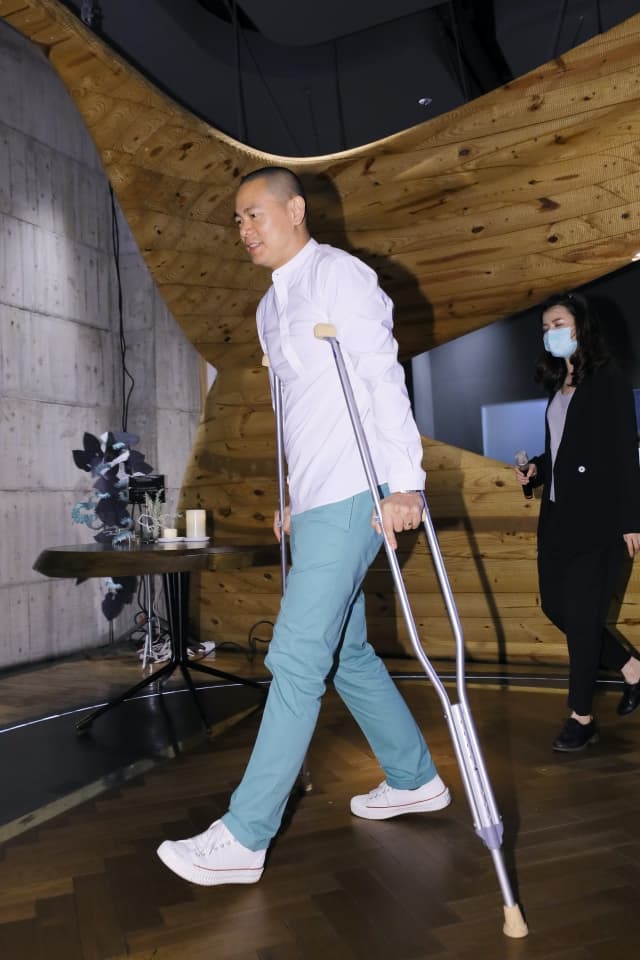 雖然近日因運動受傷，江振誠還是拿著柺杖沒休息。