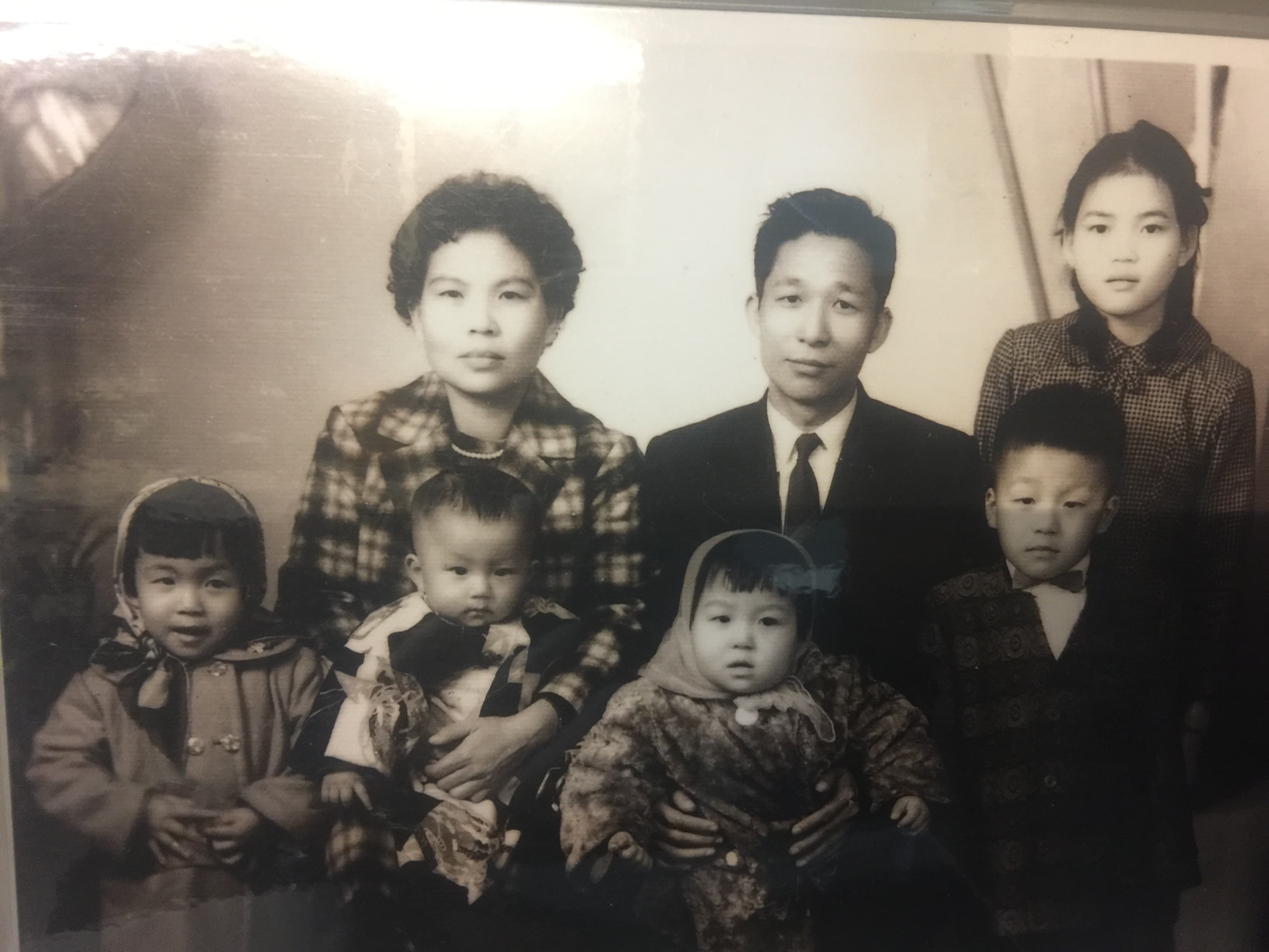 父親（後排中）是謝詠芬生命中的貴人，圖為兒時父親抱著她拍全家福。（謝詠芬提供）