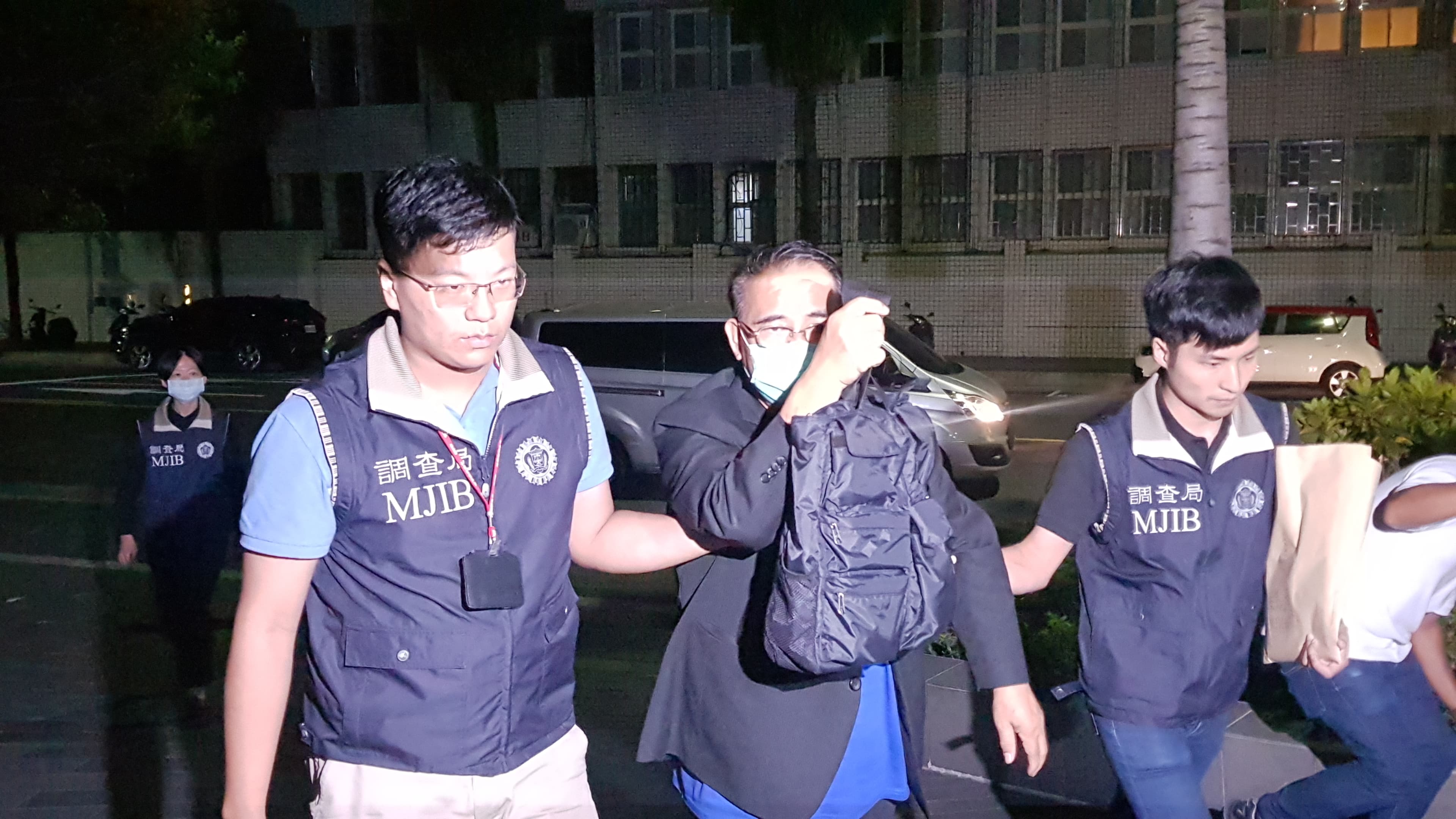 廖國棟也被送抵北檢，一直拿著包包擋前方的攝影機和閃燈光。