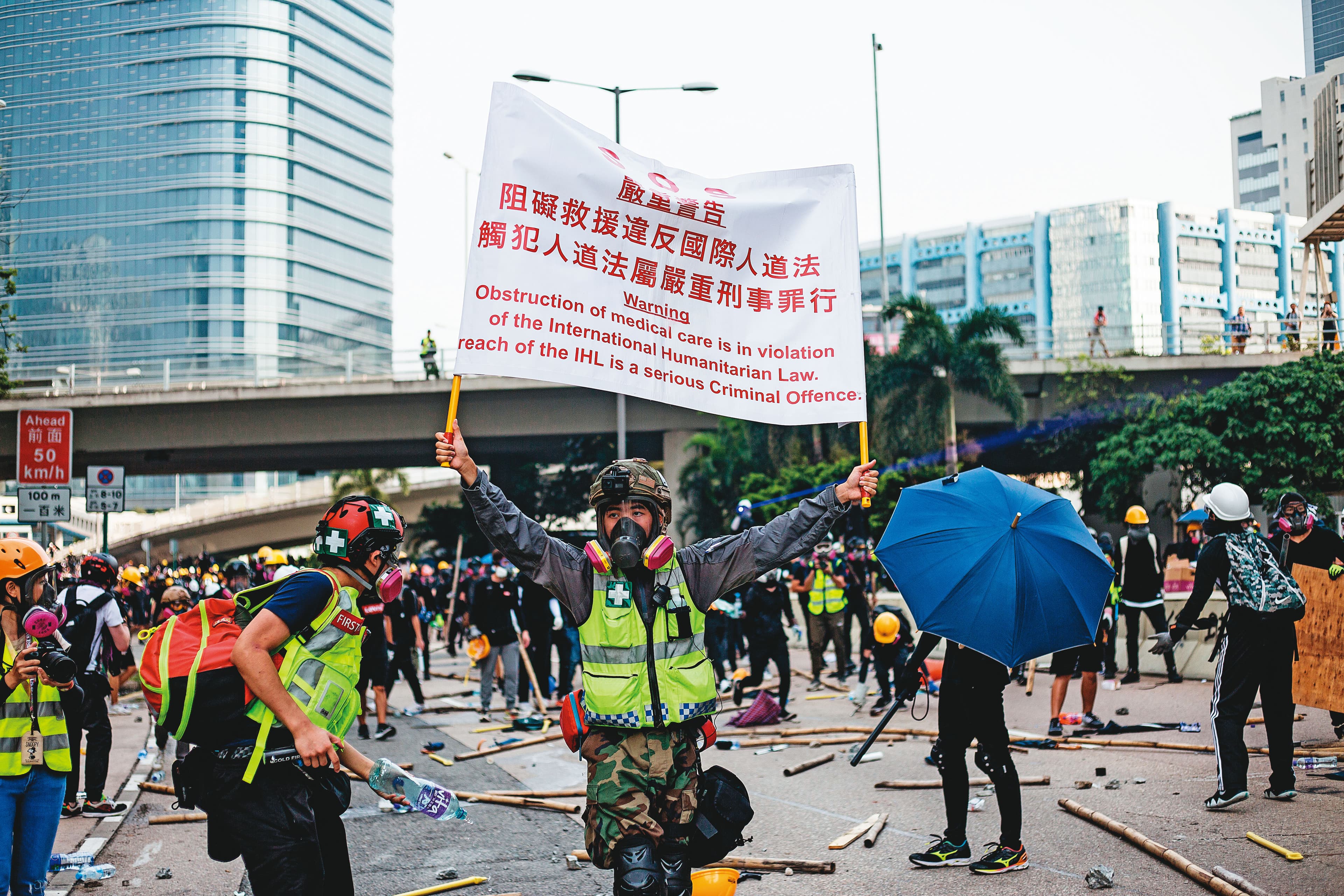 義務救護員有時也遭警察武力波及。圖為一名救護員高舉標語向警察抗議。