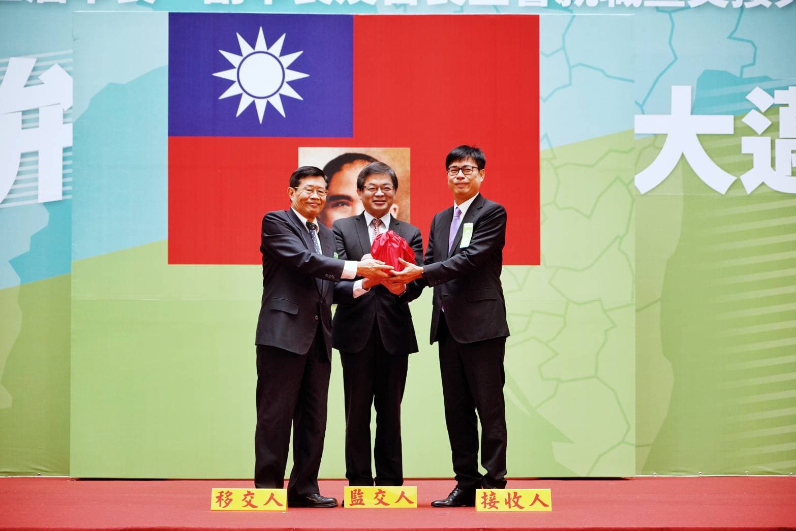典禮上，代理市長楊明州（左）將印信交給新任市長陳其邁（右），由行政院祕書長李孟諺（中）監交。
