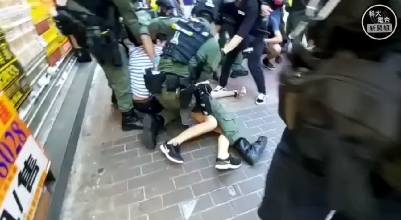 少女遭港警粗暴壓制，雖試圖反抗但根本無力抵擋。（翻攝科大電台新聞組臉書）