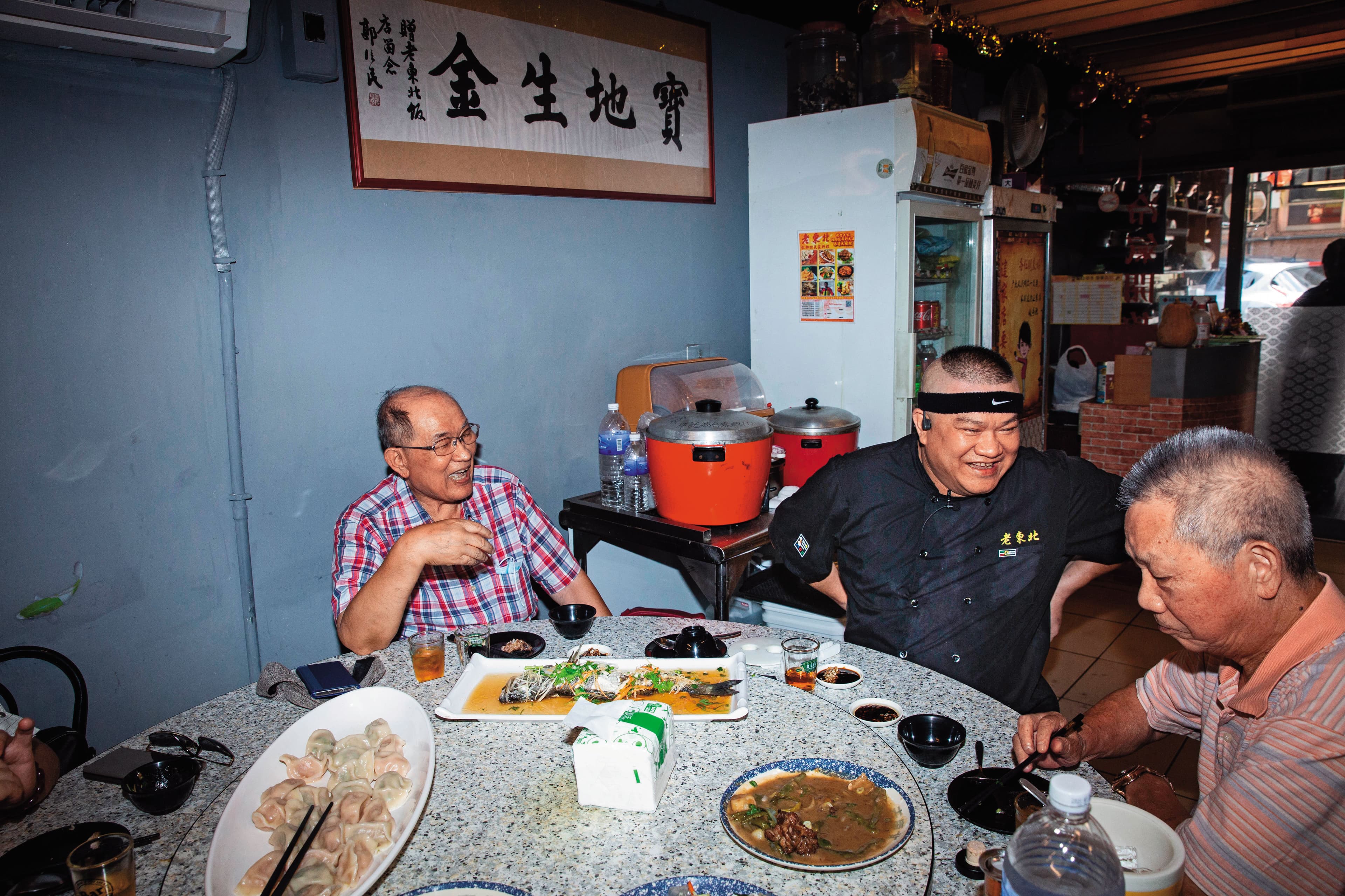 楊波（右2）炒菜之餘會向客人介紹東北菜的特色，因而與許多客人結為好友。