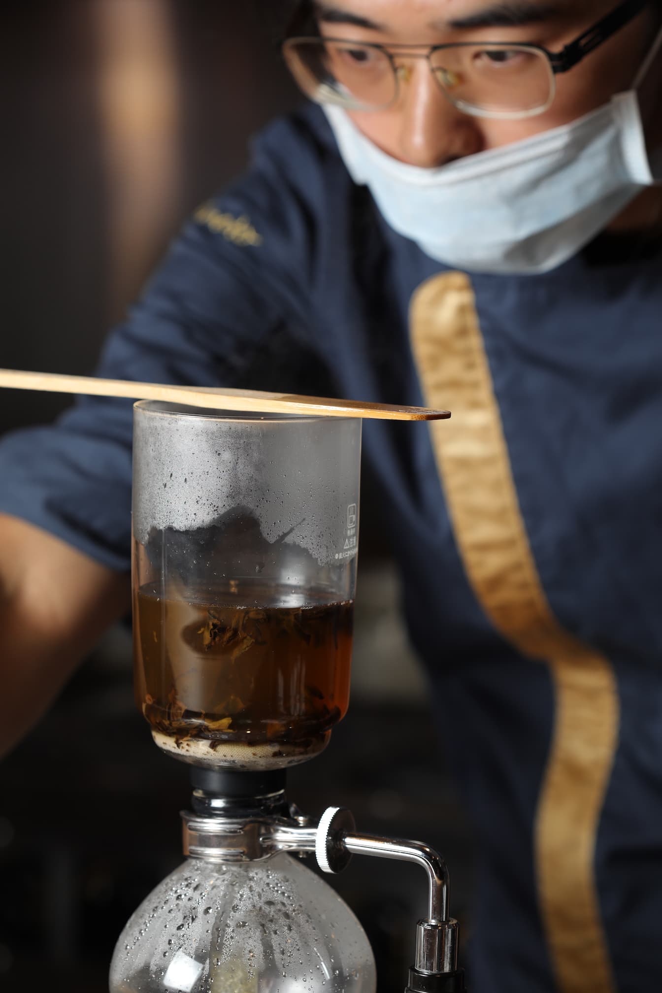 副主廚李建志以虹吸壺萃取普洱茶與鰻骨高湯。