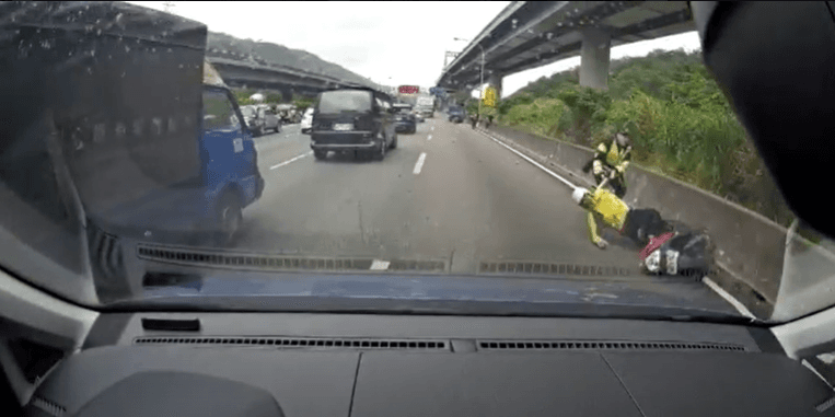 警方即時將被小貨車擦撞的趙男拉至路邊，險些遭後方車輛撞擊。（國道警察局提供）