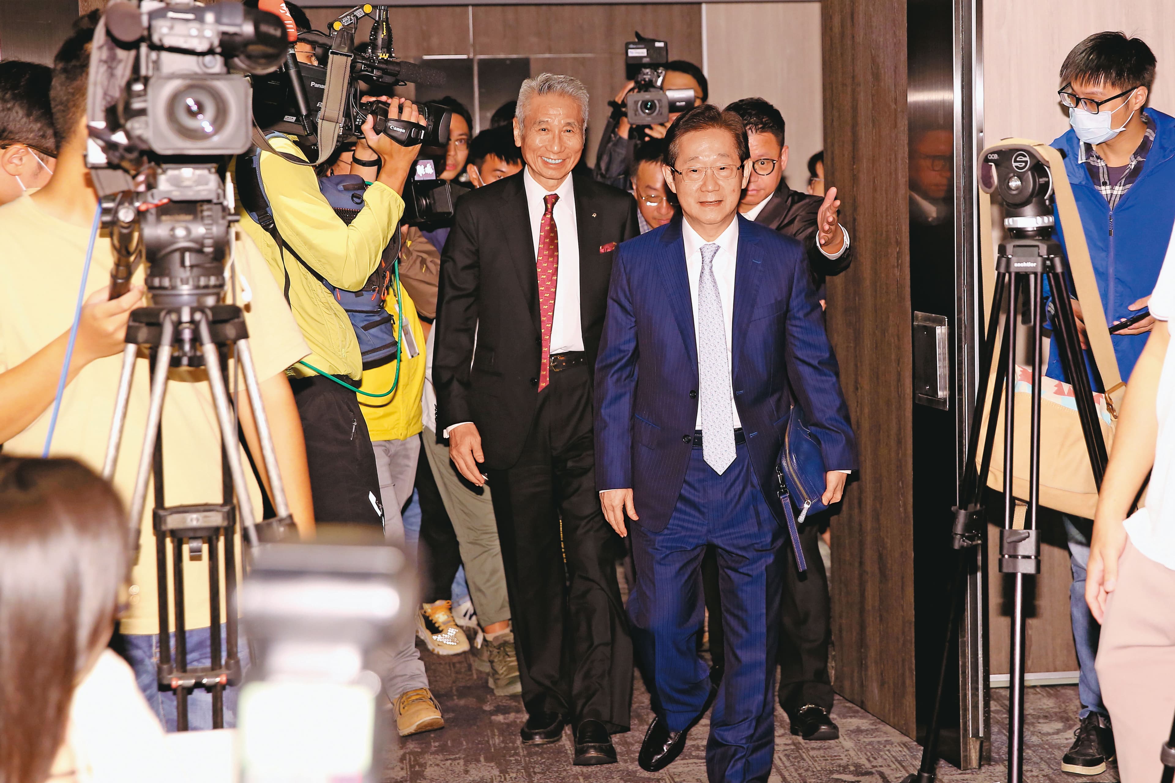 記者會上，林文淵（右）、王光祥（左）一前一後入場，主客易位的態勢不言而喻。