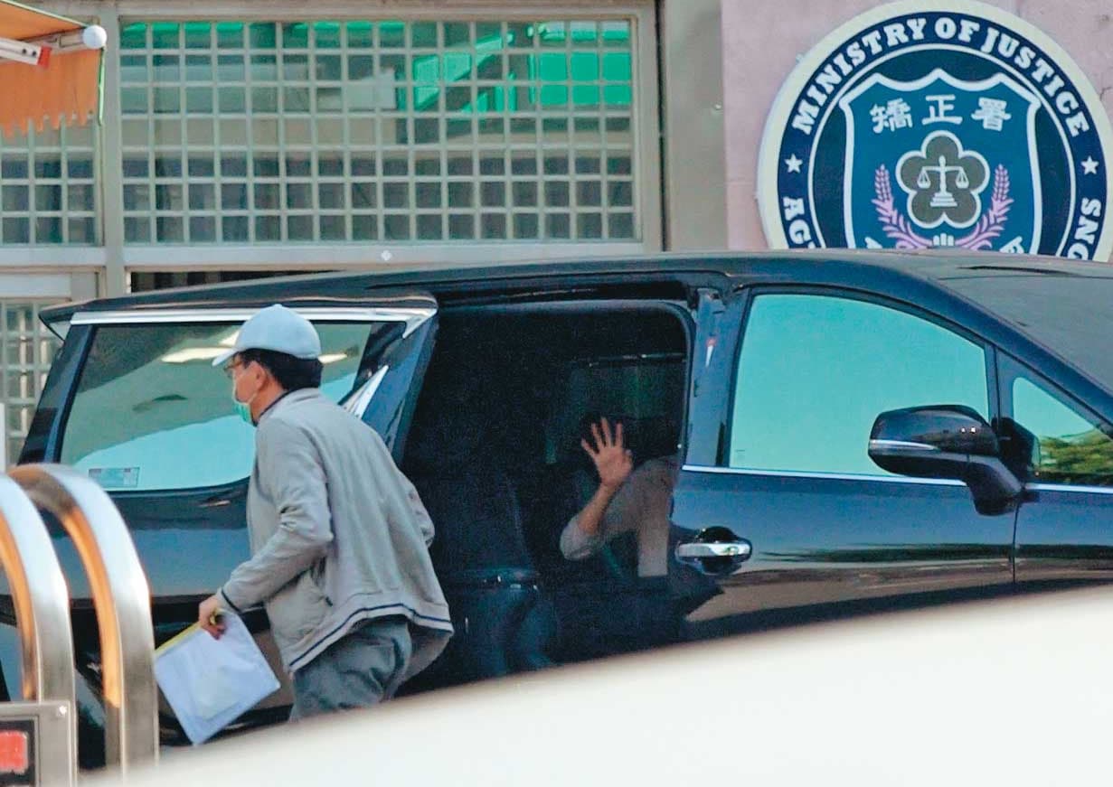 高志鵬一身鴨舌帽、口罩準時返回八德外役監，女友一路隨車相伴，還離情依依揮手向他道別。