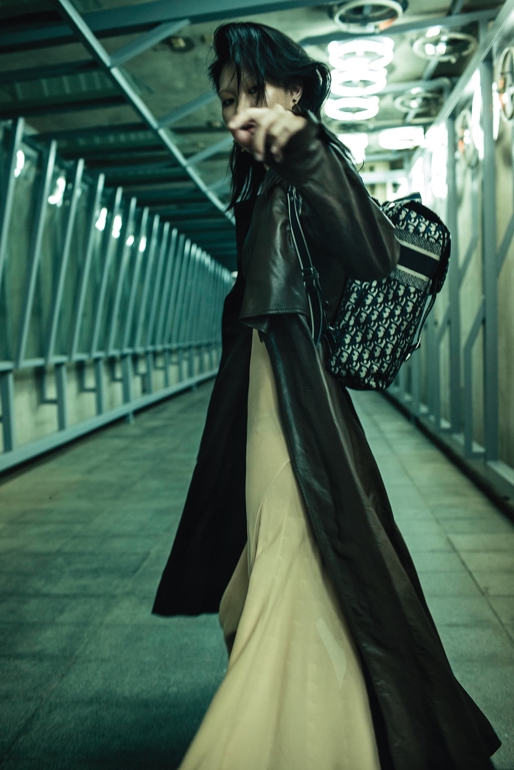 深咖啡色小羊皮風衣 NT$282,200 by BOTTEGA VENETA／粉膚色長洋裝 NT$90,100 by BOTTEGA VENETA／金色耳環 價格店洽 by CELINE／Oblique藍色斜紋刺繡帆布後背包 NT$120,000 by DIOR