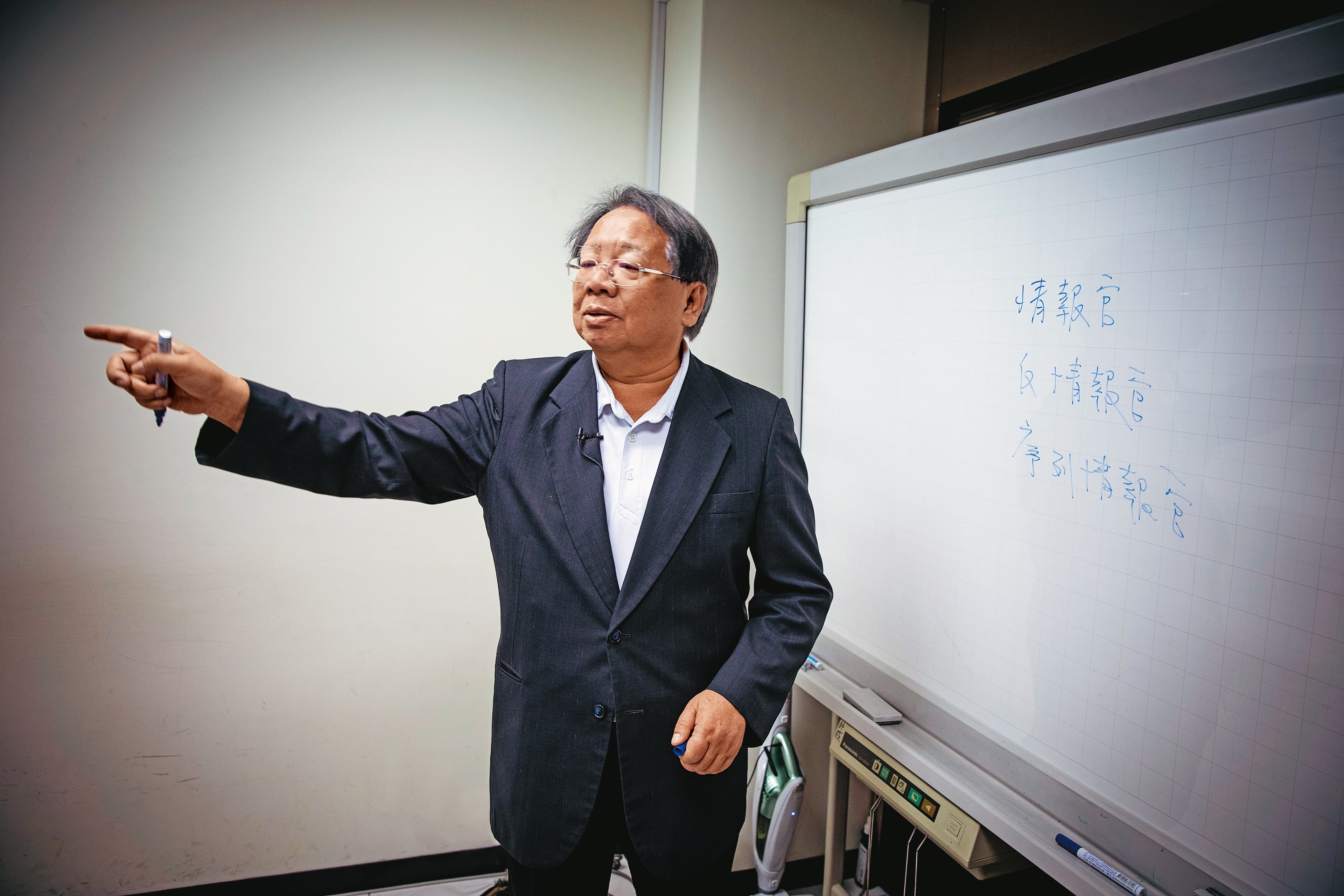 台灣戰略模擬學會小小的會議室中，有一大塊白板，張榮豐談起戰略，常不小心就把白板寫得密密麻麻。他為人謹慎，這天知道我們要拍攝，擦去較敏感的說明文字。