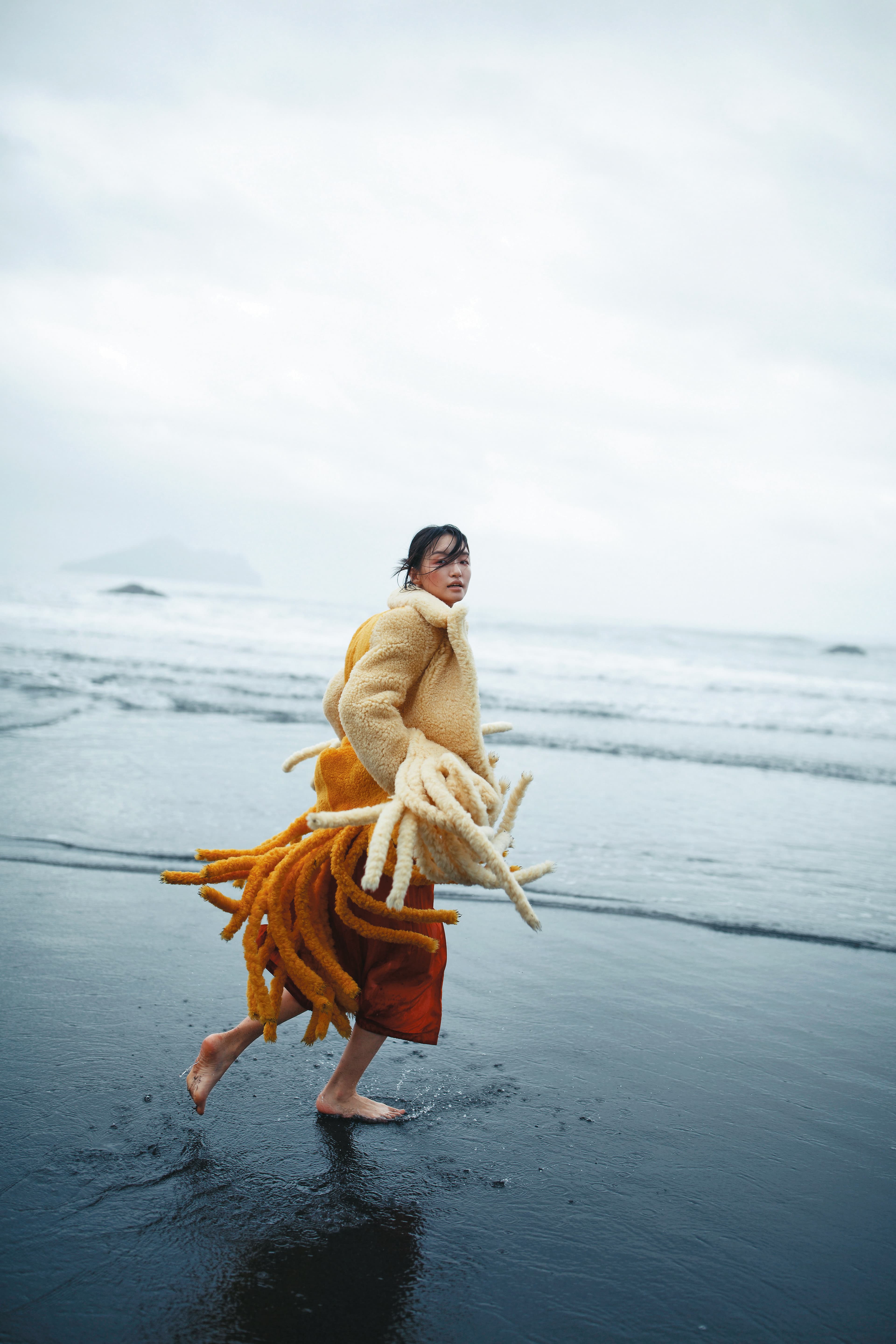 奶油黃毛絨流蘇大衣 NT$282,200 by BOTTEGA VENETA、橘色過膝洋裝 價格店洽 by COACH
