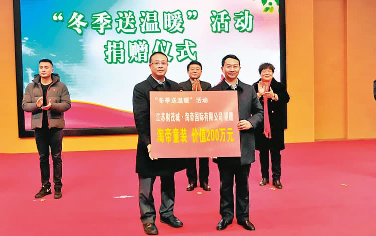 淘帝董事長周訓財（左2）自稱在中國常做善事，曾捐出市值人民幣200萬元的童裝給弱勢民眾。（翻攝網路）
