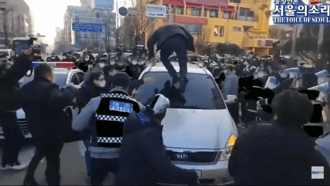 趙斗淳12日出獄，民眾跳上他乘坐的公務車洩憤。（翻攝The Voice of Seoul YouTube頻道）