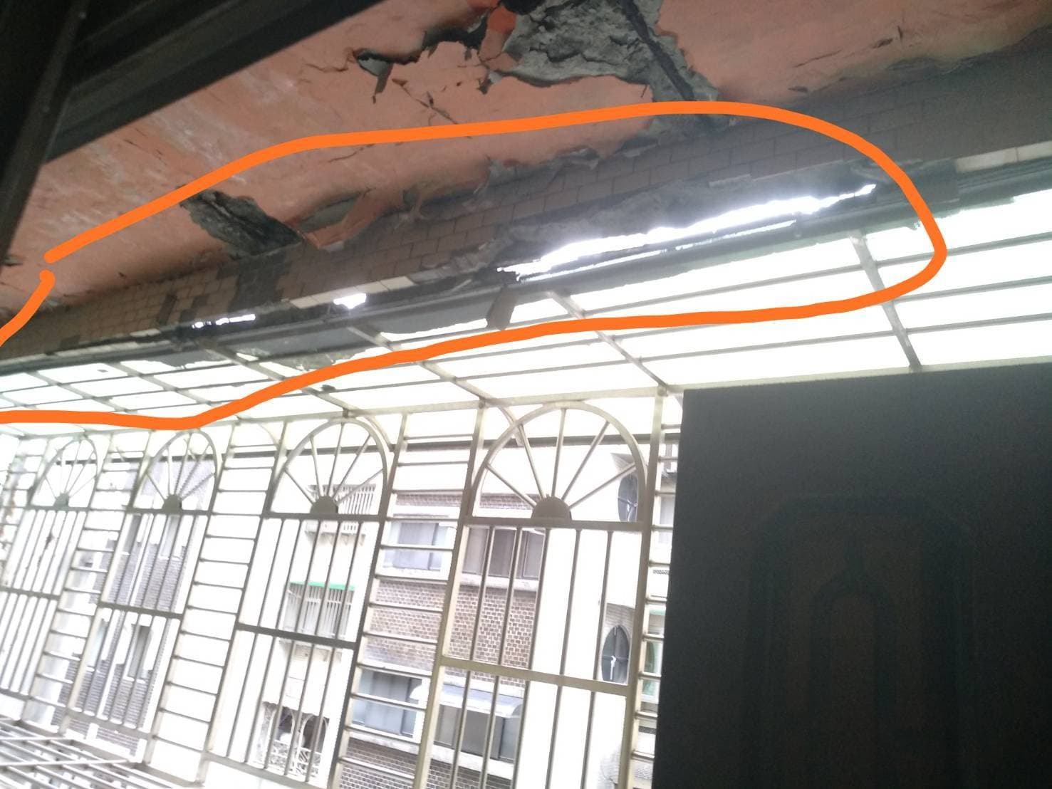 地震後自家陽台出現大量砸落的水泥塊，讓吳先生心有餘悸。（讀者提供）