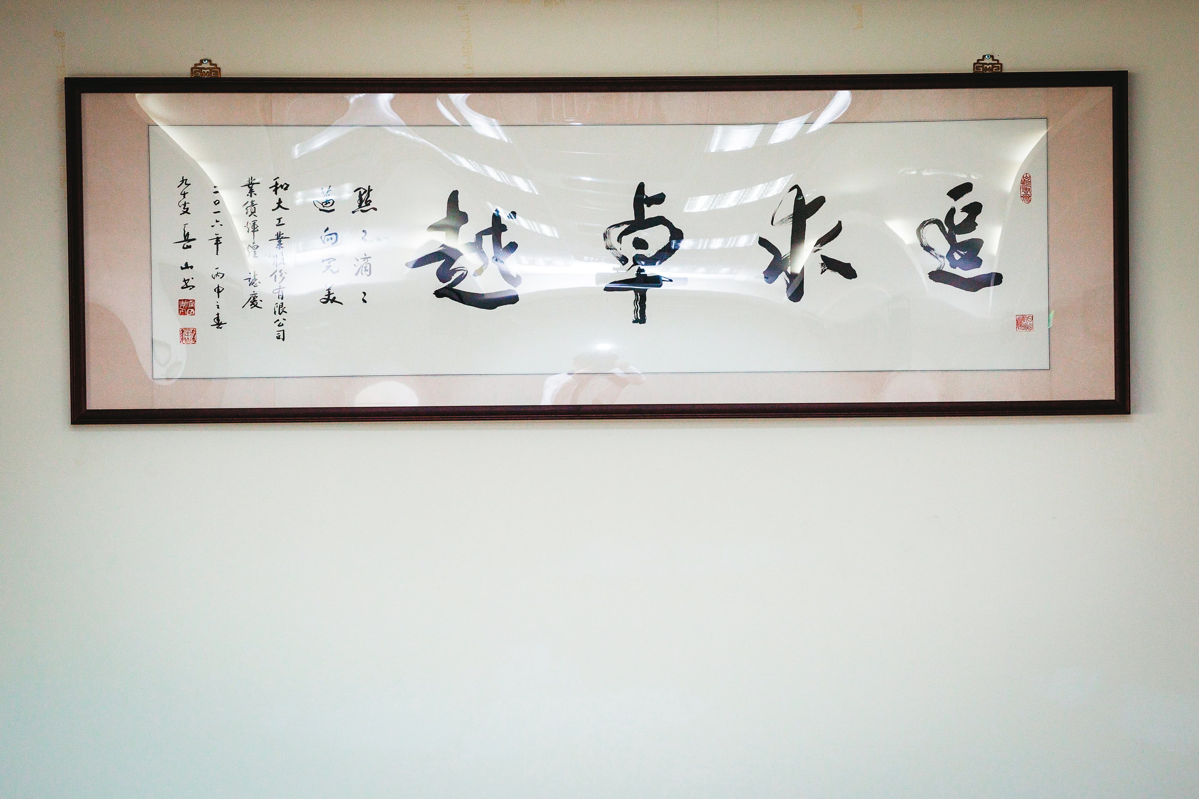 沈國榮在辦公室掛著寫有「追求卓越」的字畫，提醒自己要不斷精進。