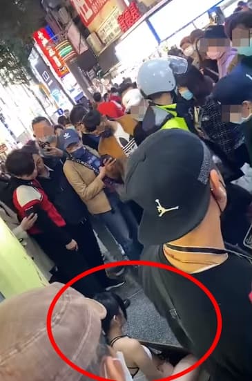 女子在街頭的行徑引發不少人駐足，還有警察到場關切。（翻攝自「爆廢公社2館」臉書）