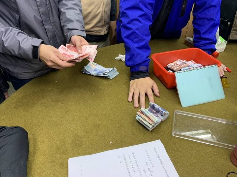 警方清算桌面上的賭資與抽頭金，現場賭資計有16萬元。（林慶祥翻攝）