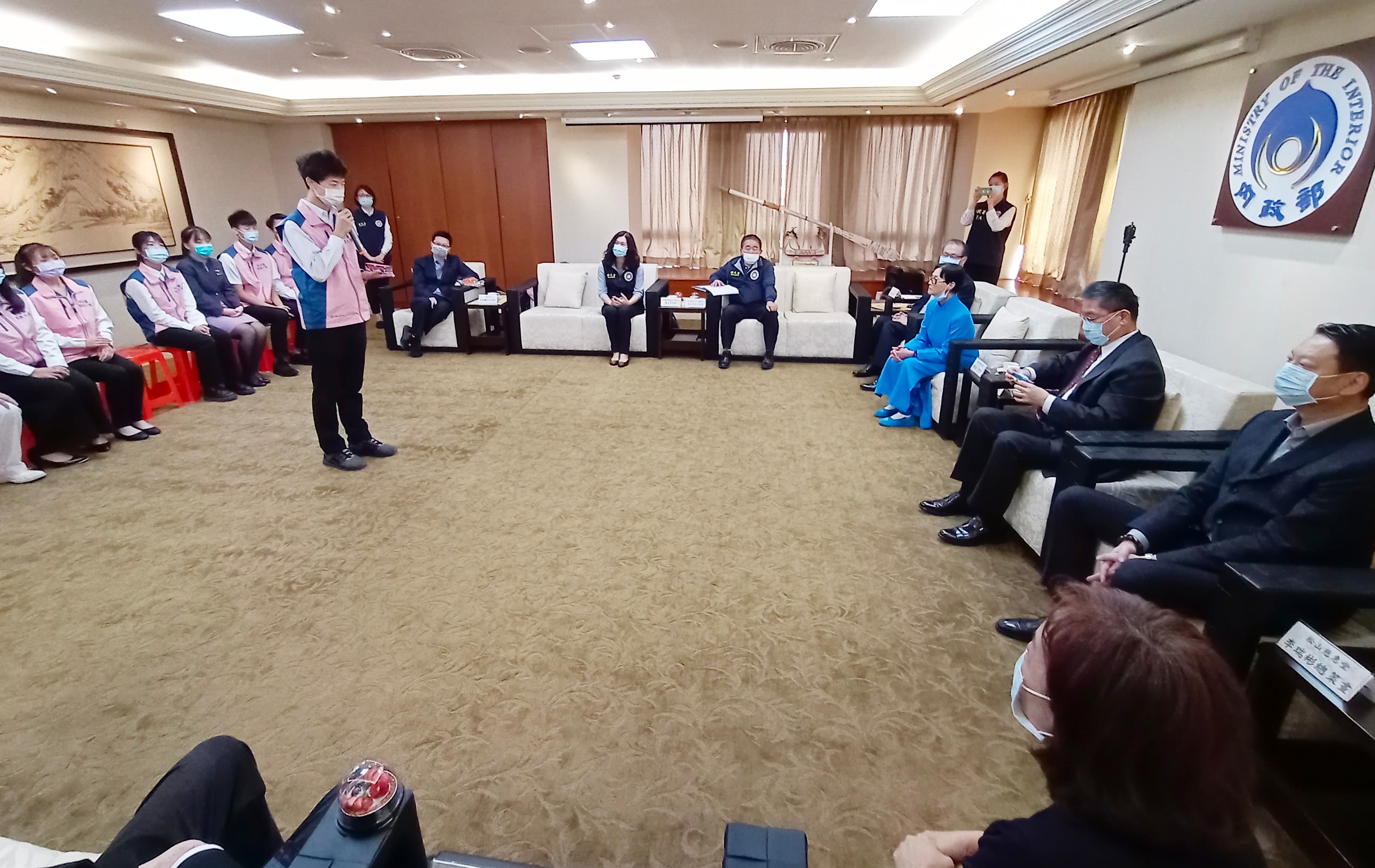 曾國揚展示自己製作的手工模型公車，徐國勇把玩直說「精緻」。（移民署提供）