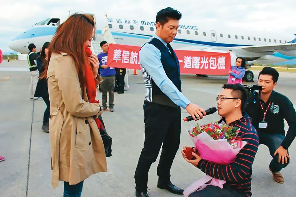 吳昭輝(右2)5年前精心安排浪漫求婚,帶著當時還是女友的妻子(左)搭乘曙光專機,在停機坪單膝下跪求婚,愛情故事還登上報紙頭版。(華信航空提供)