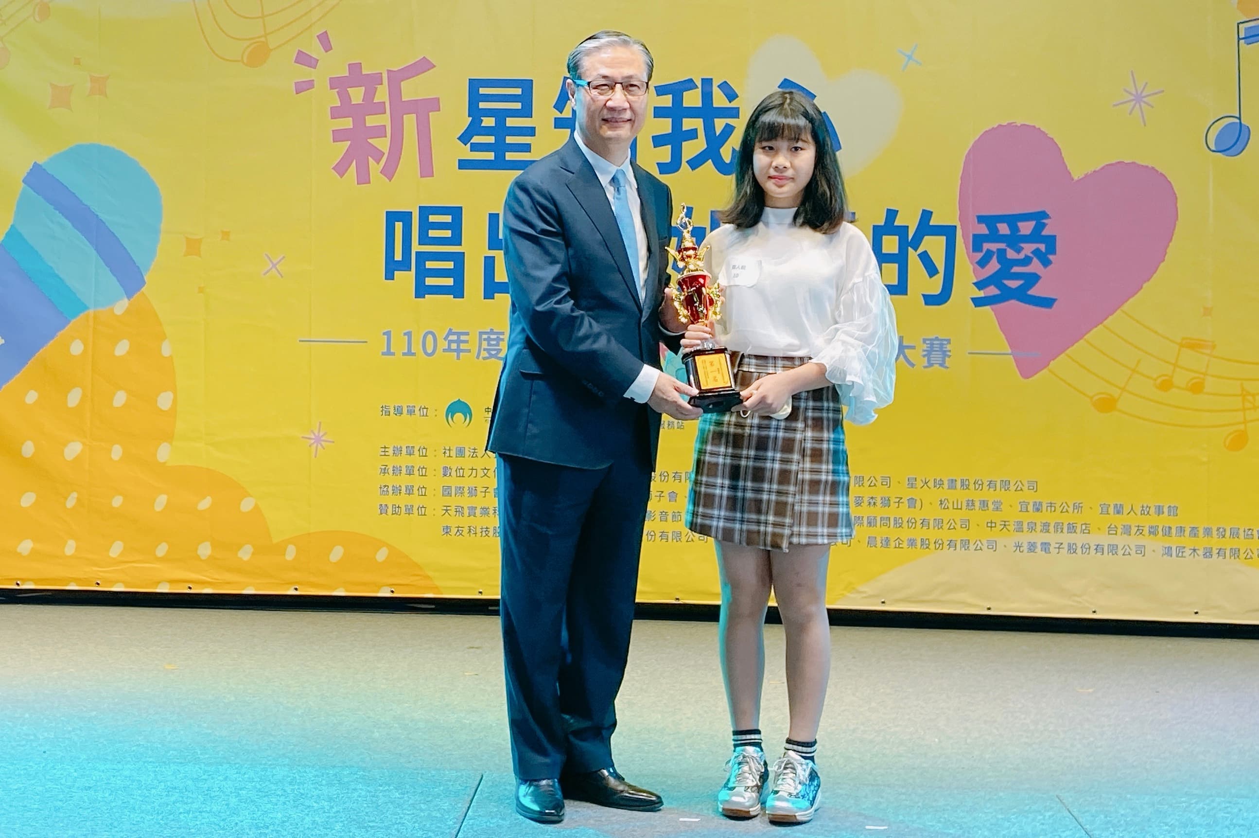 鐘署長頒贈獎盃給獲得個人組第一名新住民子女王舒妍。（移民署提供）