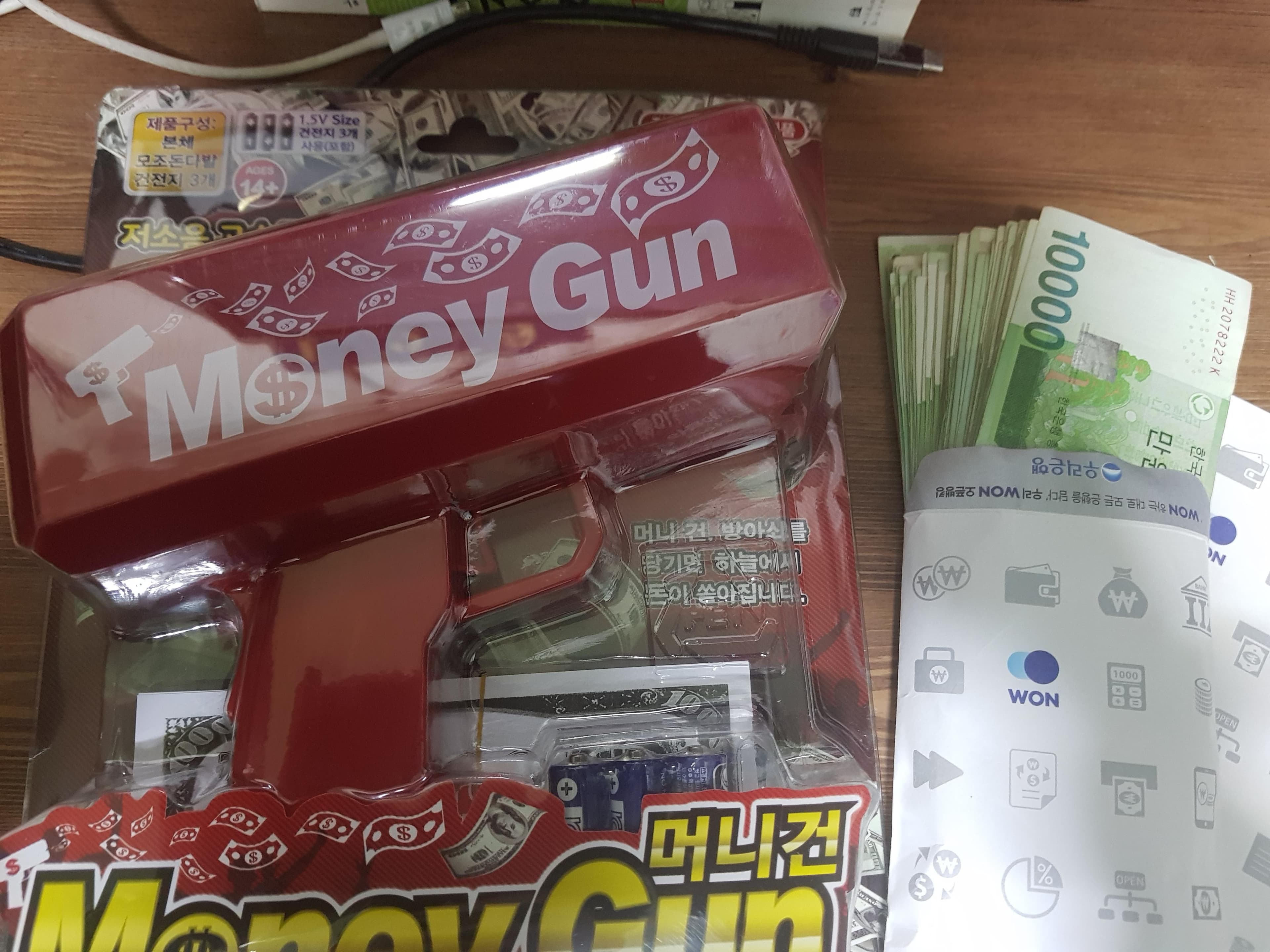 發文者買了鈔票槍、還準備一大疊韓幣萬元紙鈔，要在父母節展現「正港的亂花錢」。（翻攝自dogdrip）