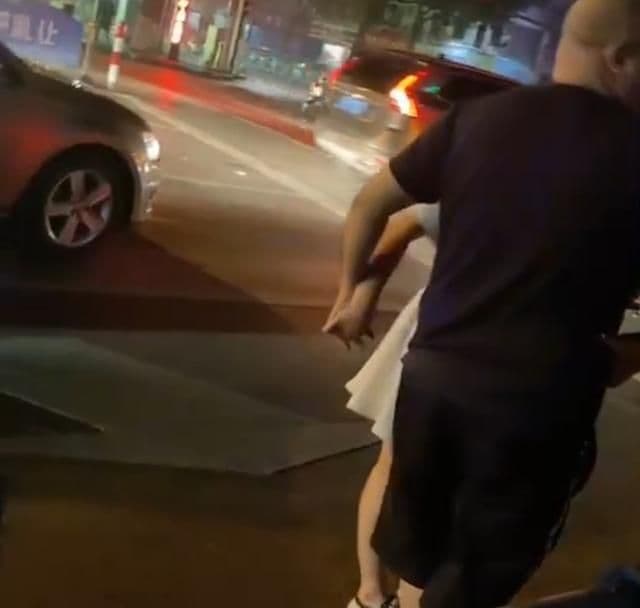 女駕駛還出奇招，十指緊扣男駕駛的手，讓一旁路都傻眼。（翻攝搜狐新聞）