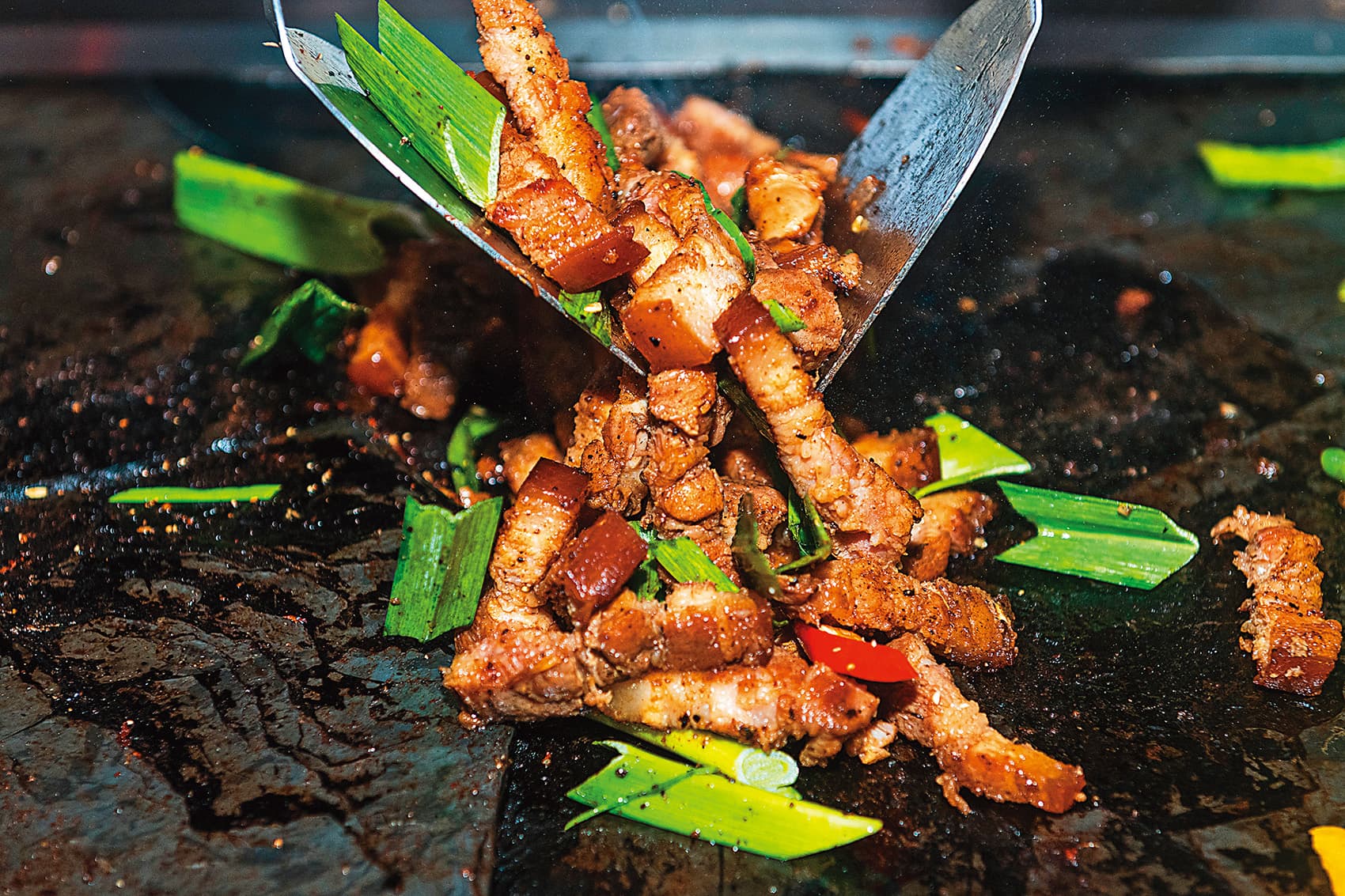 「石板烤肉DIY原味山豬肉」撒上馬告一起拌炒調味。（200元／份）