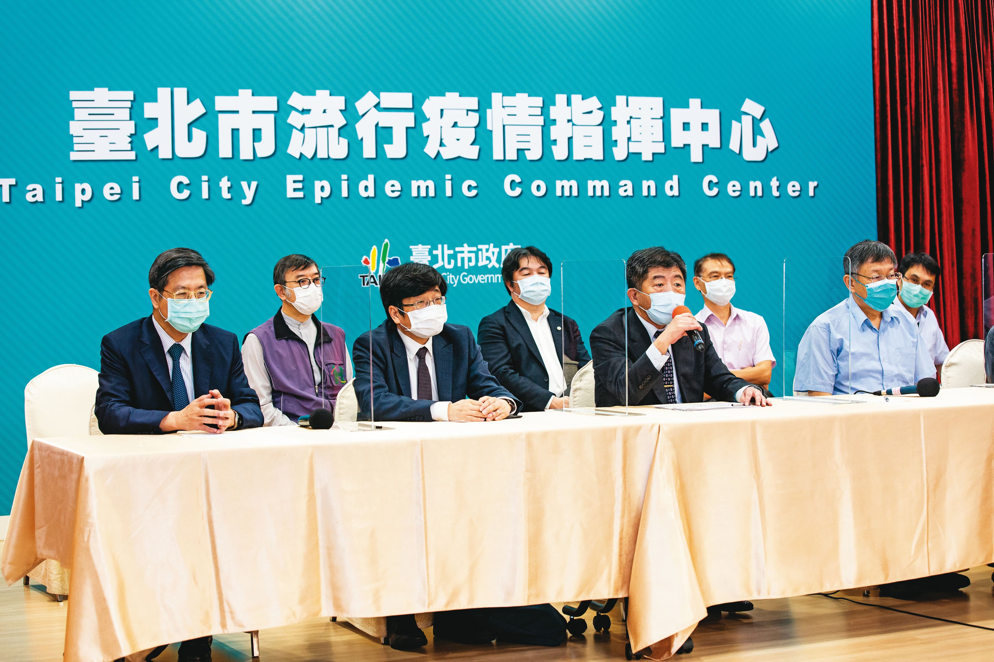 陳時中（前排右2）14日率指揮中心官員與台北市長柯文哲（前排右1）合體開記者會，聯手宣布北市率先在感染熱區設立快篩站。