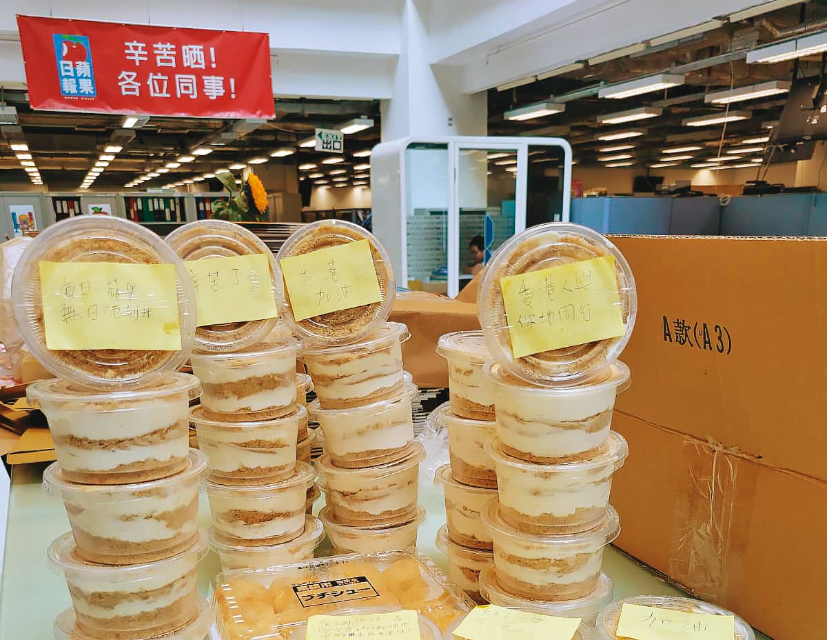 《蘋果》的最後一夜，湧入大量老同事、市民的鼓勵，有人送來啤酒、限量蛋糕、大量食物門外還有人喊要不要幫忙載員工回家，冒雨喊加油。圖為《蘋果》辦公室裡堆滿打氣食物的一角。（受訪者提供）