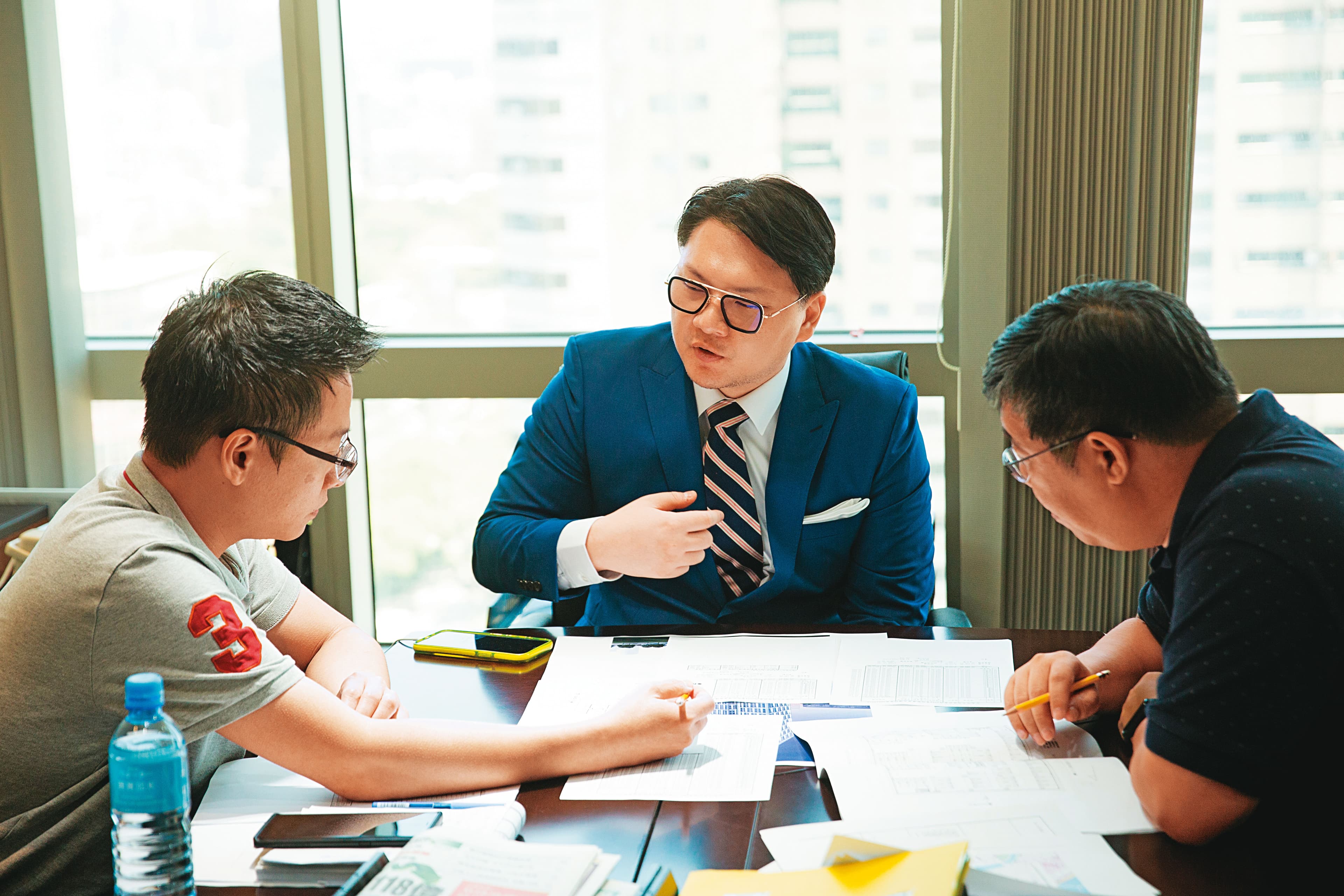 採訪當天，鍾育霖（中）正在商談旗下建案規劃，不到40歲的他已經是一家百億集團操盤人。