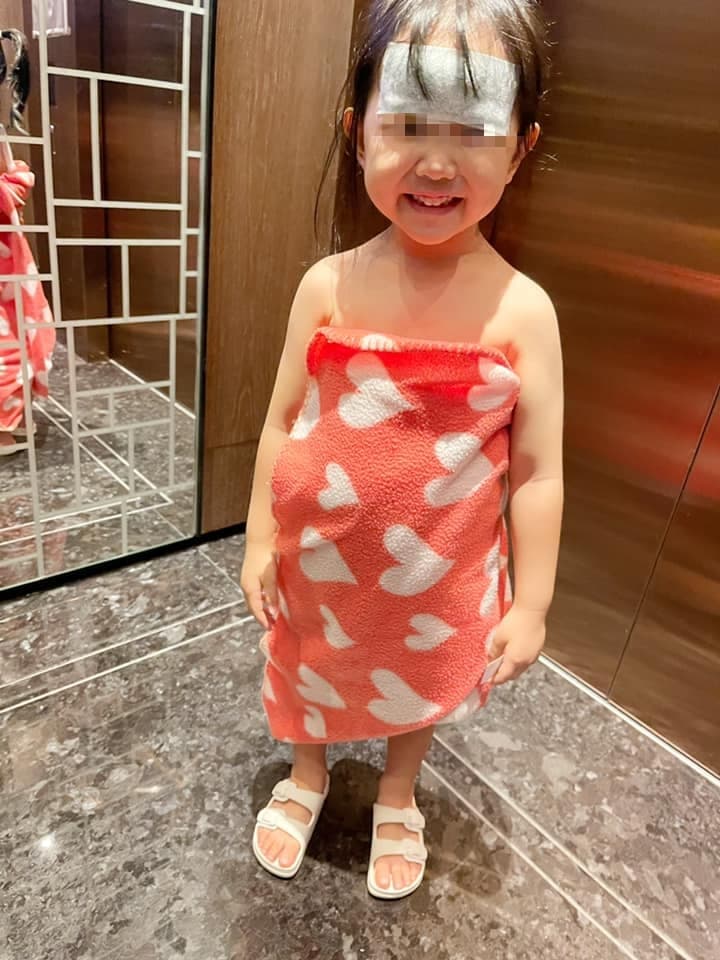 嚴立婷女兒發高燒在診所不小心吐了出來，只好跟診所借了小毛毯裹著身體。（翻攝自嚴立婷臉書）