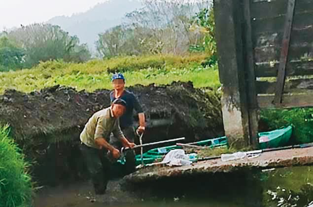 黃順昱疑似雇工偷挖堤岸，破壞古蹟水門和便橋，被村民逮個正著。（讀者提供）