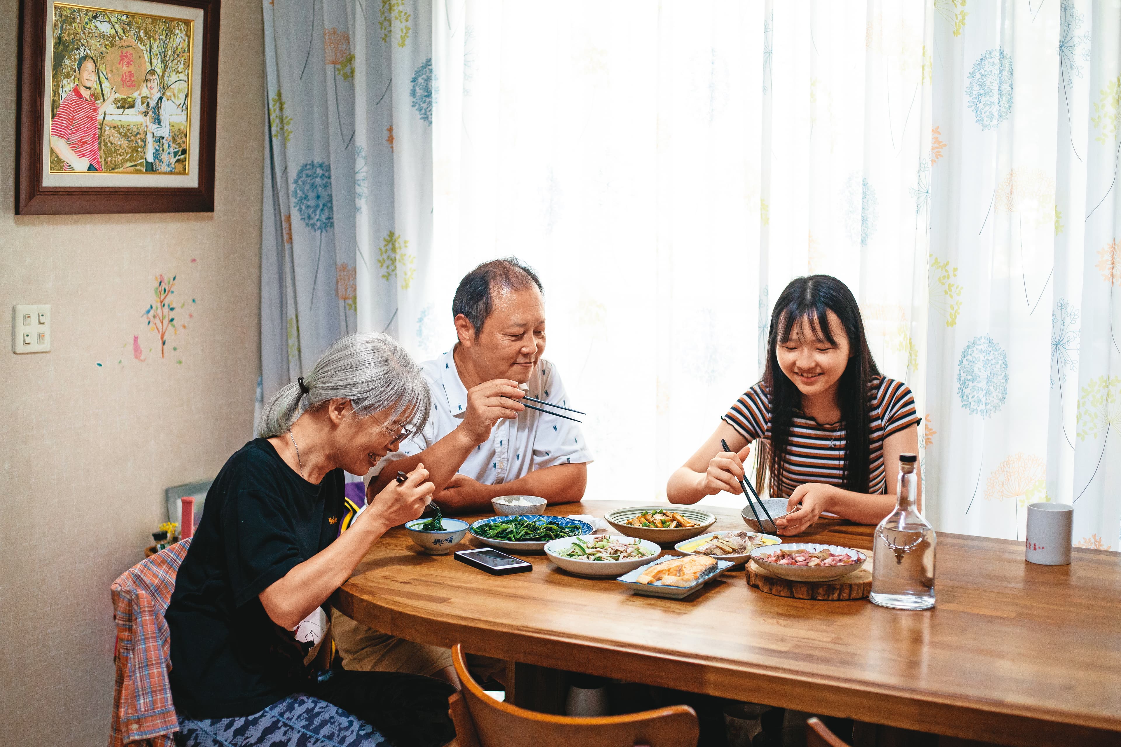 萬美麗（左）在外奔波，老公嚴文龍（中）扛起煮飯打理家務之責，小女兒嚴卉聿（右）從小就習慣媽媽會半夜出門接生。