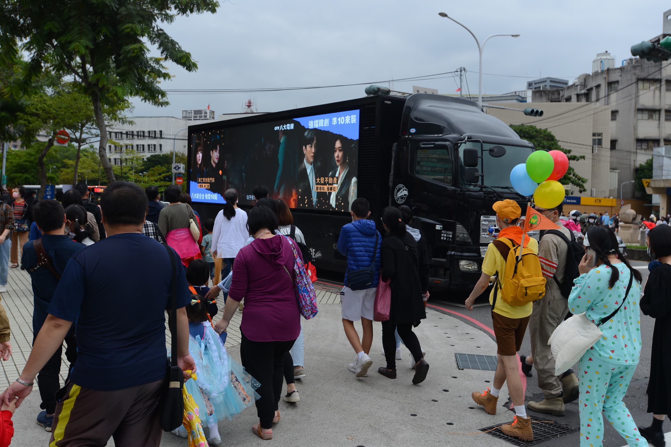民眾佇足觀賞行動廣告車放送的韓劇預告。（八大提供）