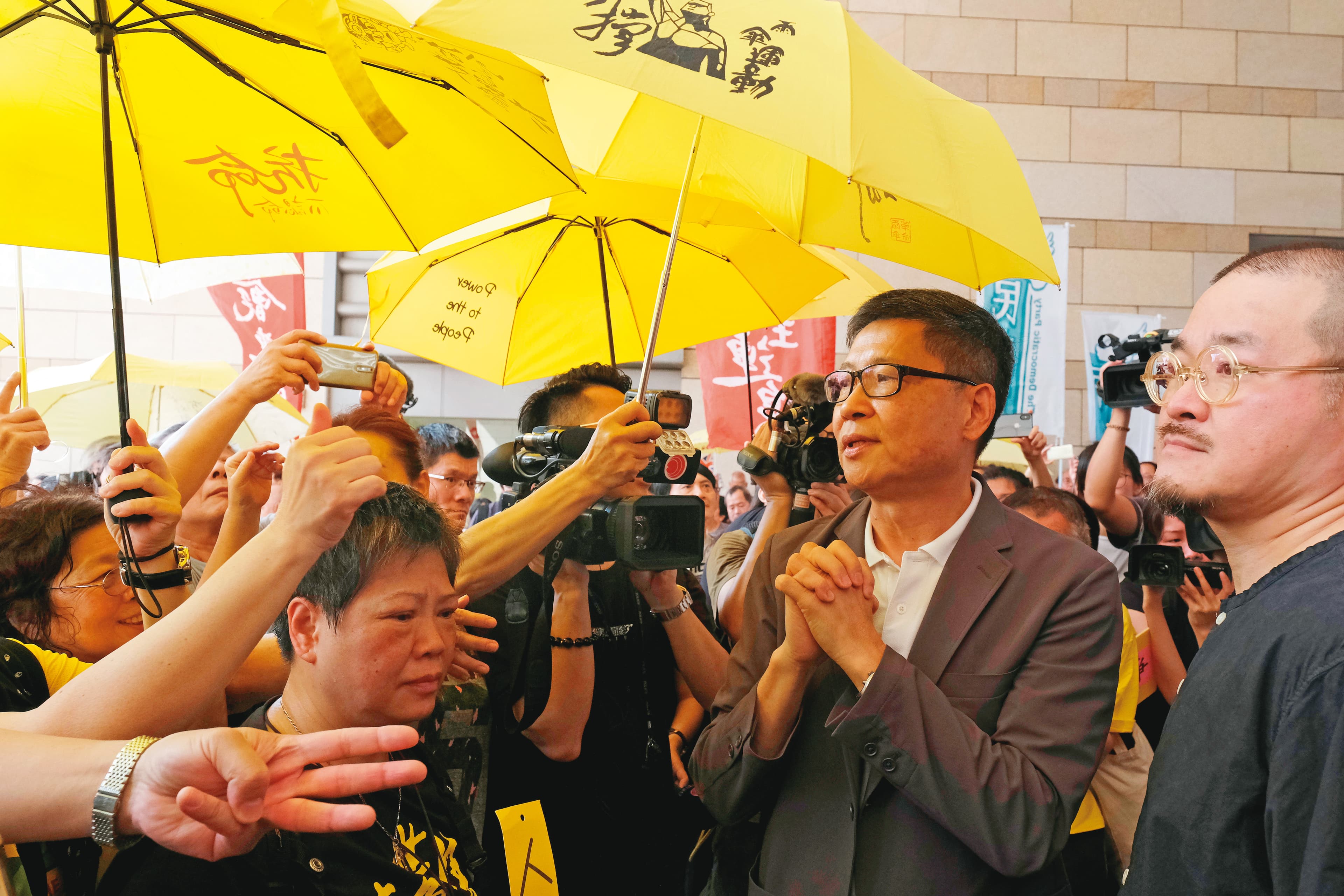 2019年4月24日，陳健民（右2）被判即時入獄16個月。圖為支持者們在法庭外聲援被告，右1為同日被判即時入獄的邵家臻。（達志影像）