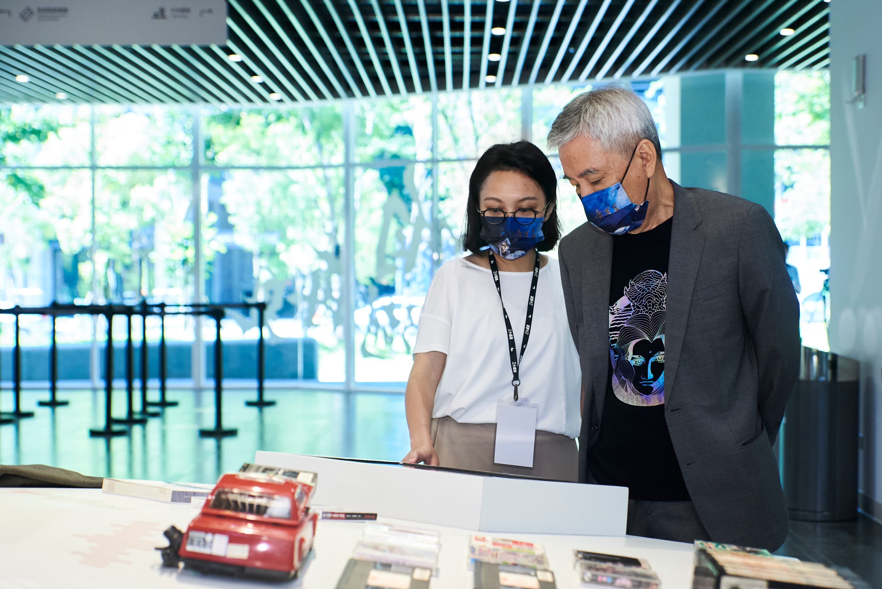 黃文章與女兒看著紀念展收藏，憶起與弟弟黃文擇小時候的生活點滴。（霹靂國際多媒體提供）