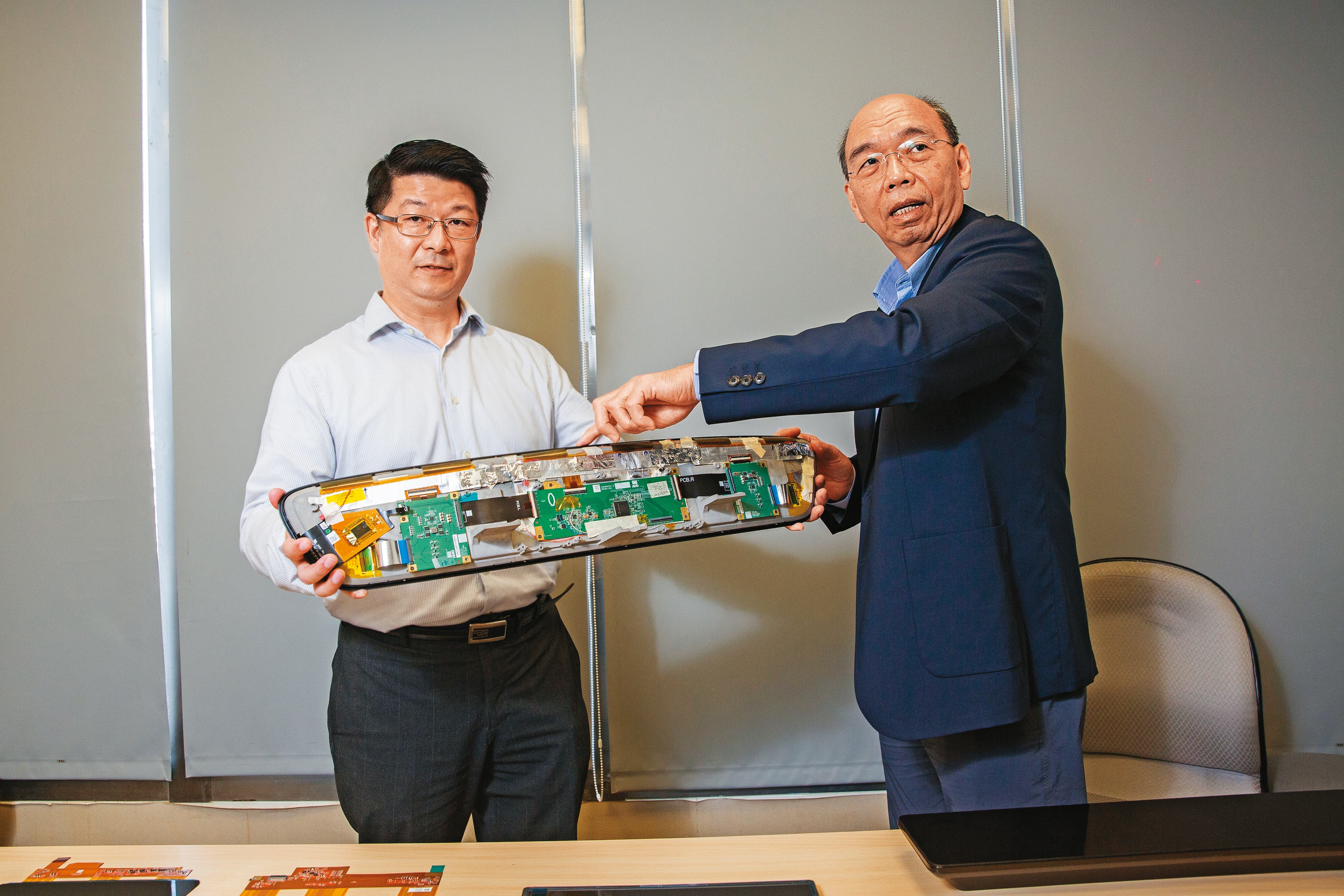 奇景光電執行長吳炳昌（右）秀出30.4吋的6K前裝螢幕機構，並親自解釋，至少得用上6顆驅動IC。