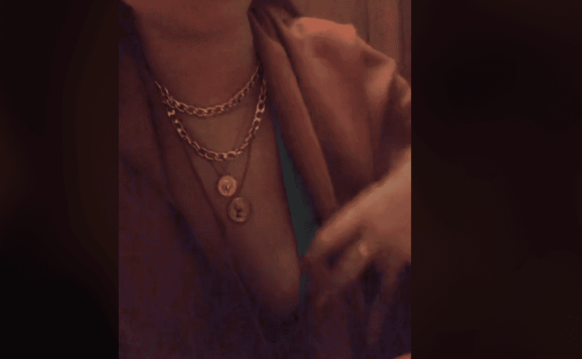 女子肩披羊毛圍巾，遮住胸前呼之欲出的渾圓嫩胸。（翻攝抖音影片@slayraslaye） 