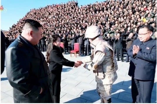 北韓官員（右）畢恭畢敬地和金主愛（中）握手。（翻攝自朝鮮中央TV）