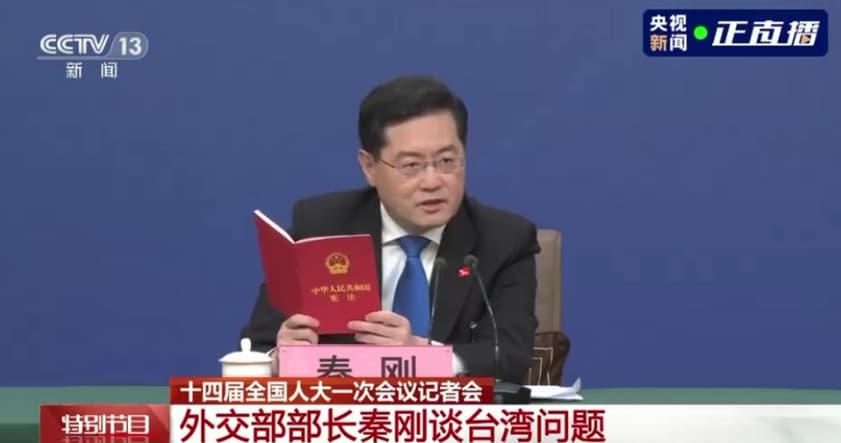 秦剛今在記者會上，拿出中國《憲法》翻閱，並引述起內容，「台灣是中華人民共和國的神聖領土的一部分。」（翻攝自央視）