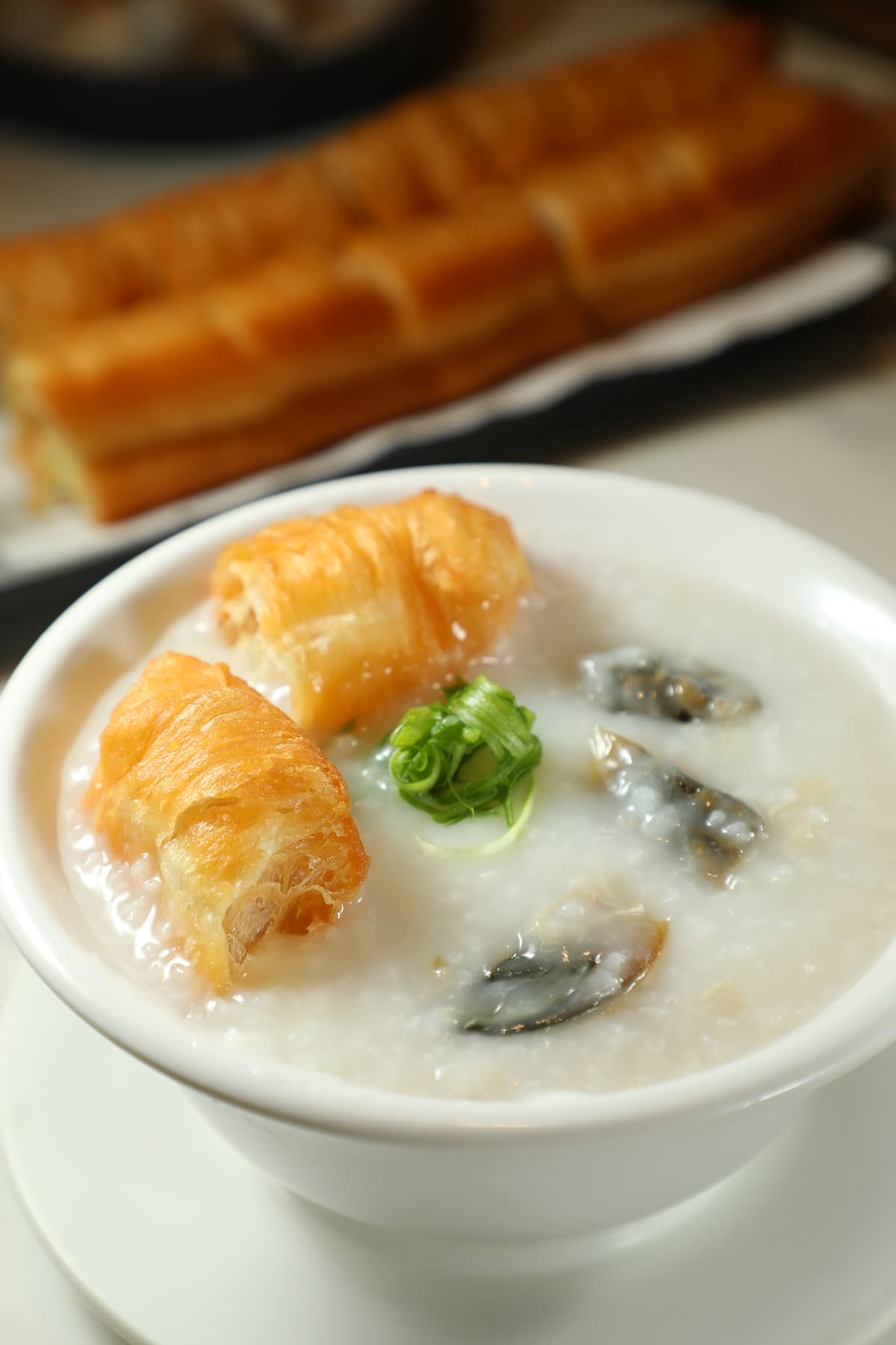 靠得住的「皮蛋瘦肉粥」（右，港幣46元／碗）清爽有味，與「鮮炸油條」（左，港幣28元／份）搭配相得益彰。
