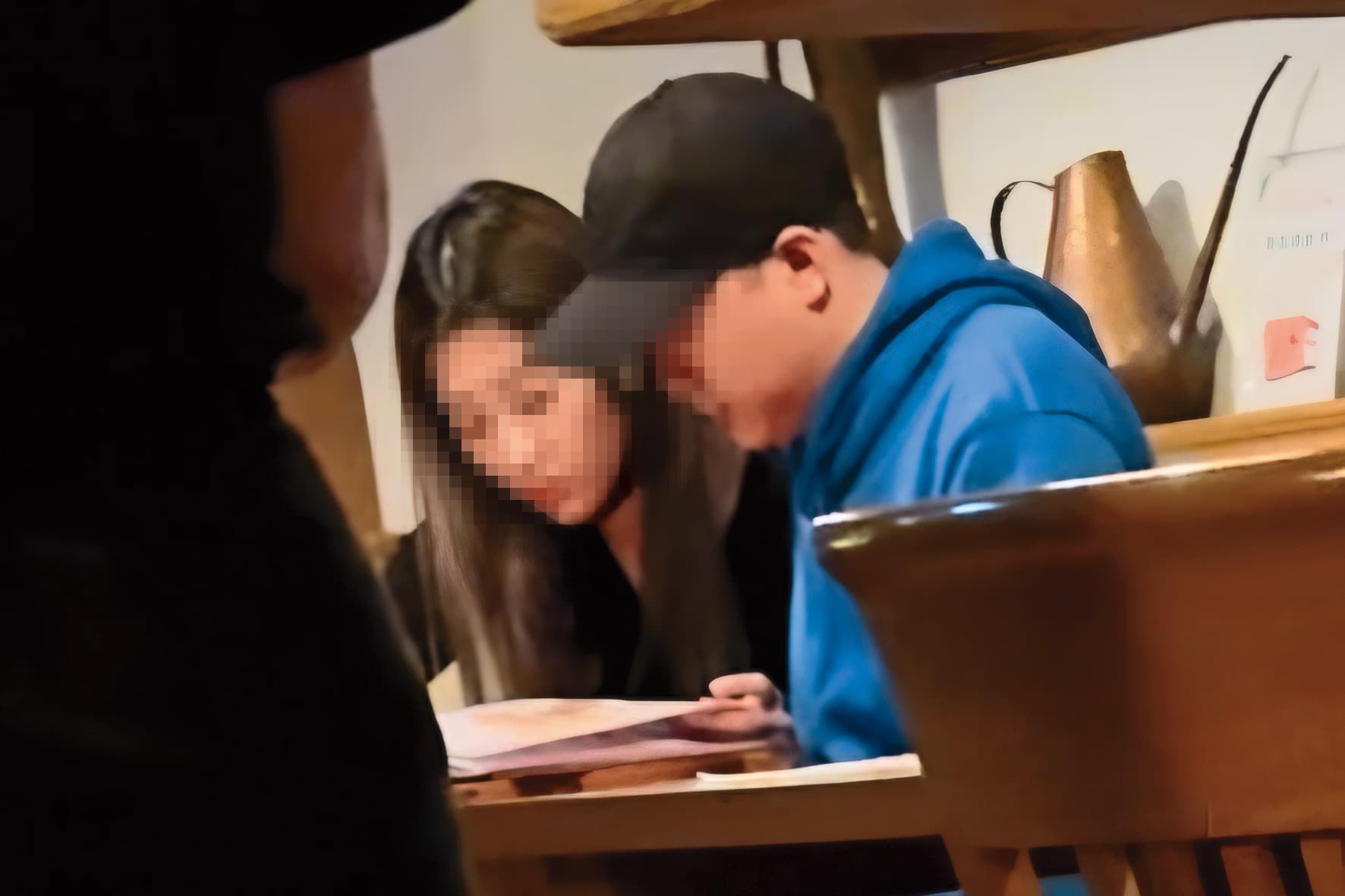   3月31日 黑帽男晚間帶樂兒去吃晚餐，兩人坐緊緊一起看菜單。（讀者提供）