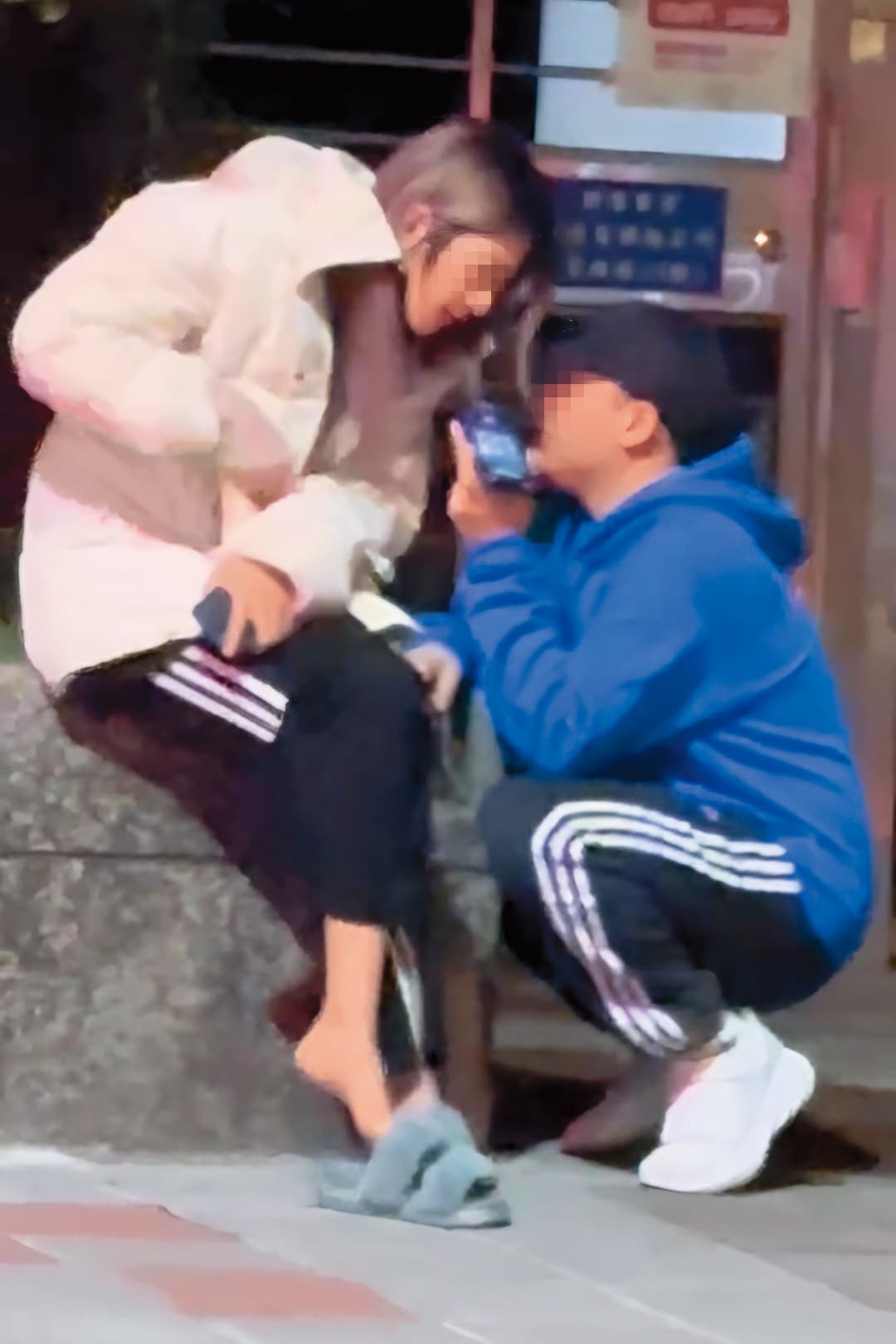 3月31日樂兒接到電話坐在路邊，黑帽男蹲下和她同跟友人講電話。（讀者提供）
