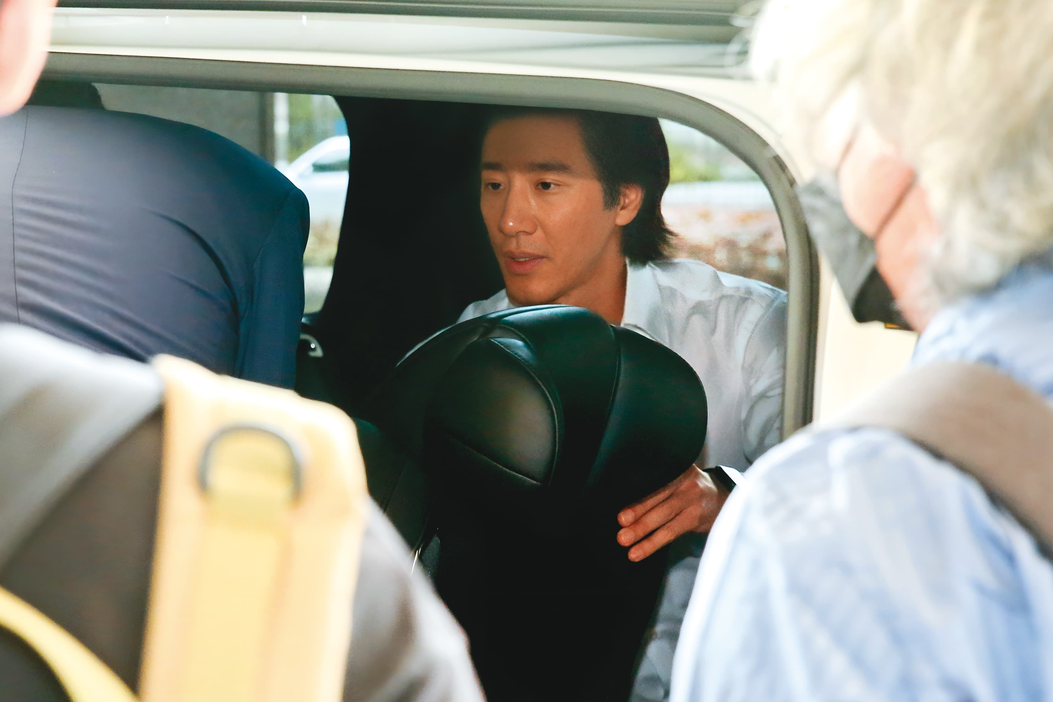 6月28日12：32，上了車後，王力宏貼心幫律師與工作人員喬起位置，展現親和力。