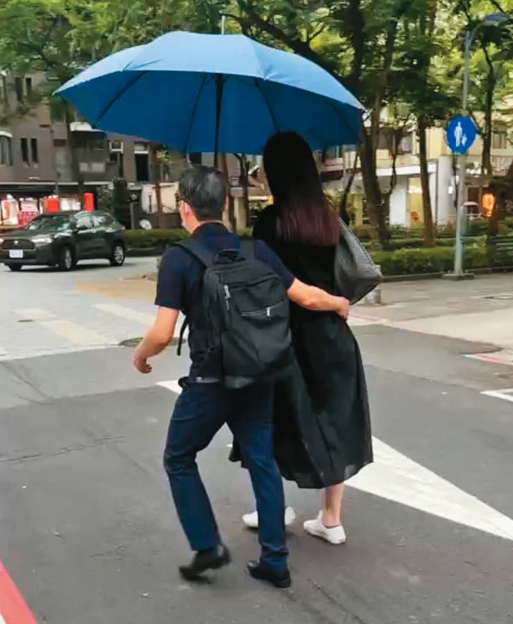 4月19日14：32，張晉源（左）和A女（右）一起撐傘遮陽時，一隻手還不忘摟著女方的腰。