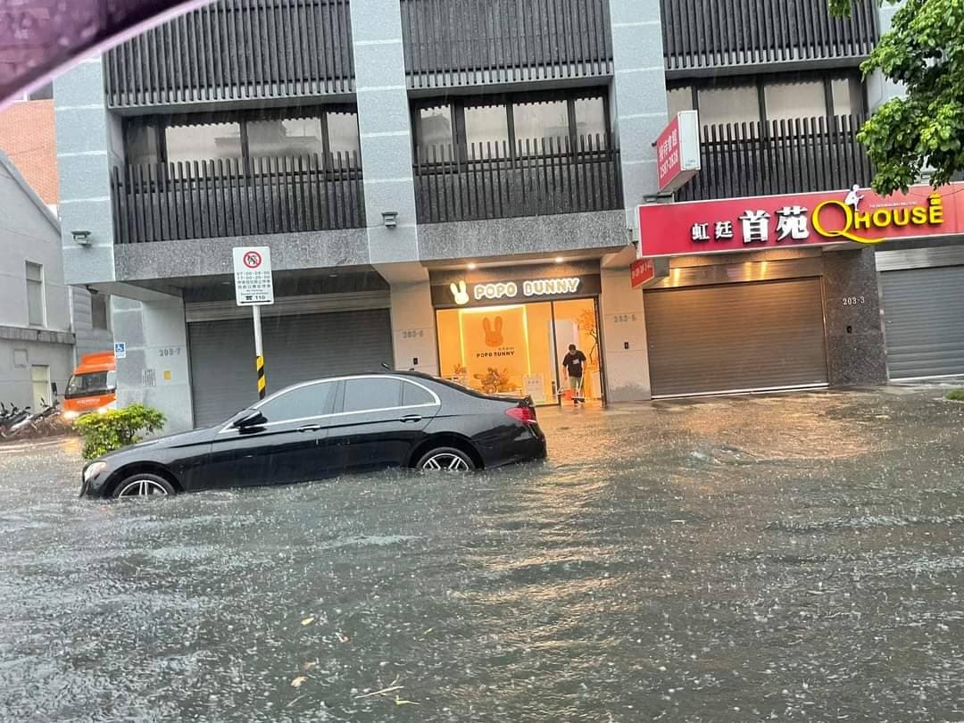 北市重慶北路積水成河，有汽機車駕駛疑似因愛車拋錨下車推行。（翻攝自記者爆料網）