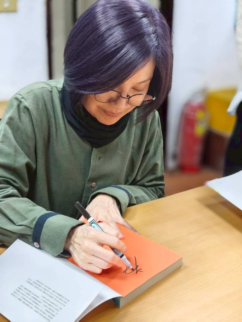唐美雲簽名時笑說像被罰寫名字。（紙風車劇團提供）